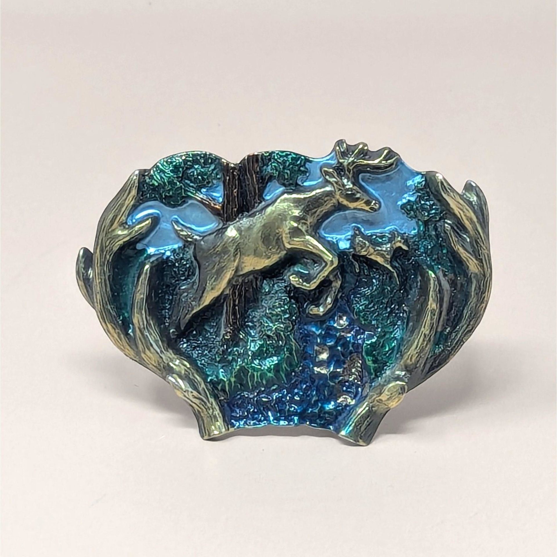 A vintage 1970s belt buckle with a leaping doe in enamel and brass-toned metal accents on a neutral background.
