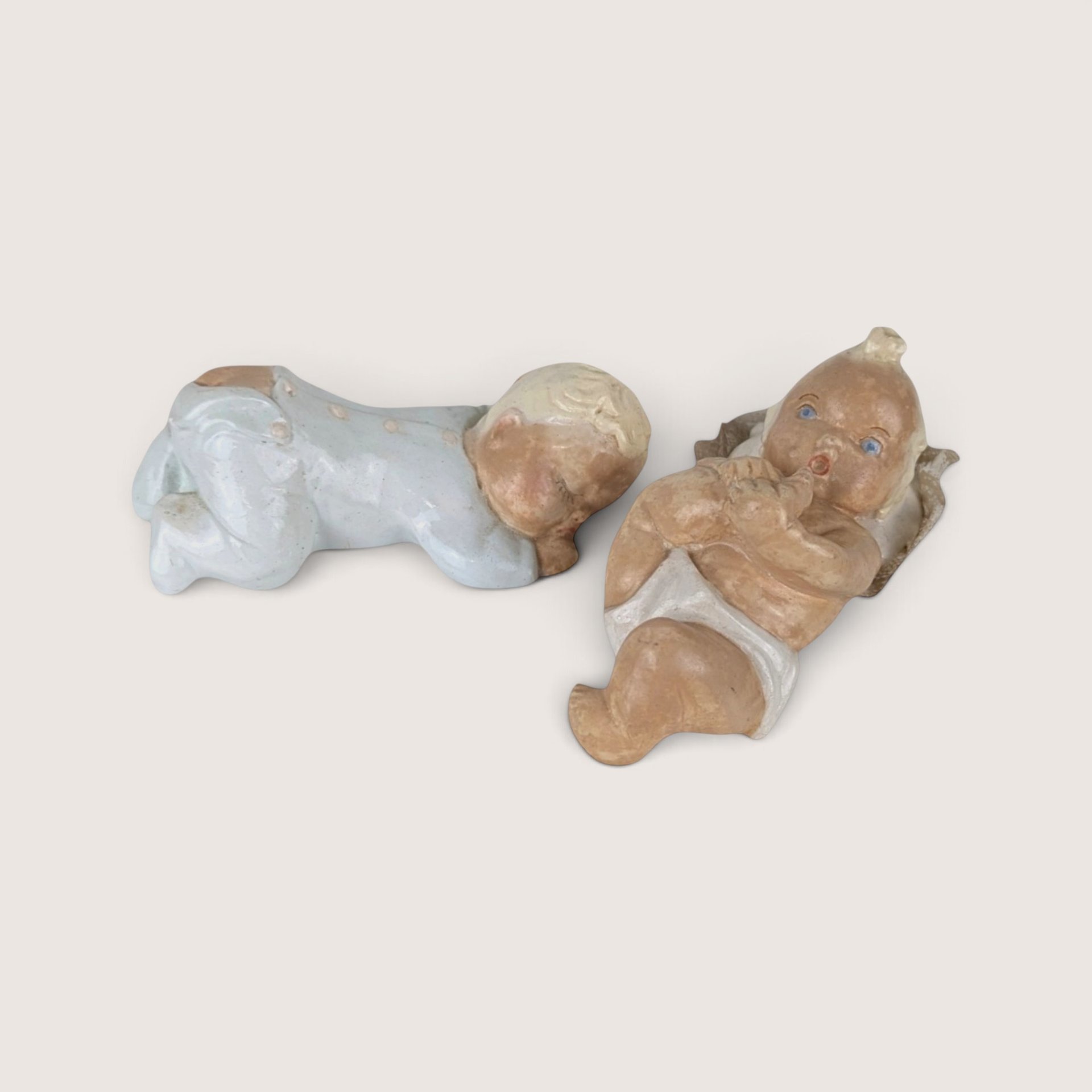 Vintage pair of chalkware baby figurines showing signs of age.