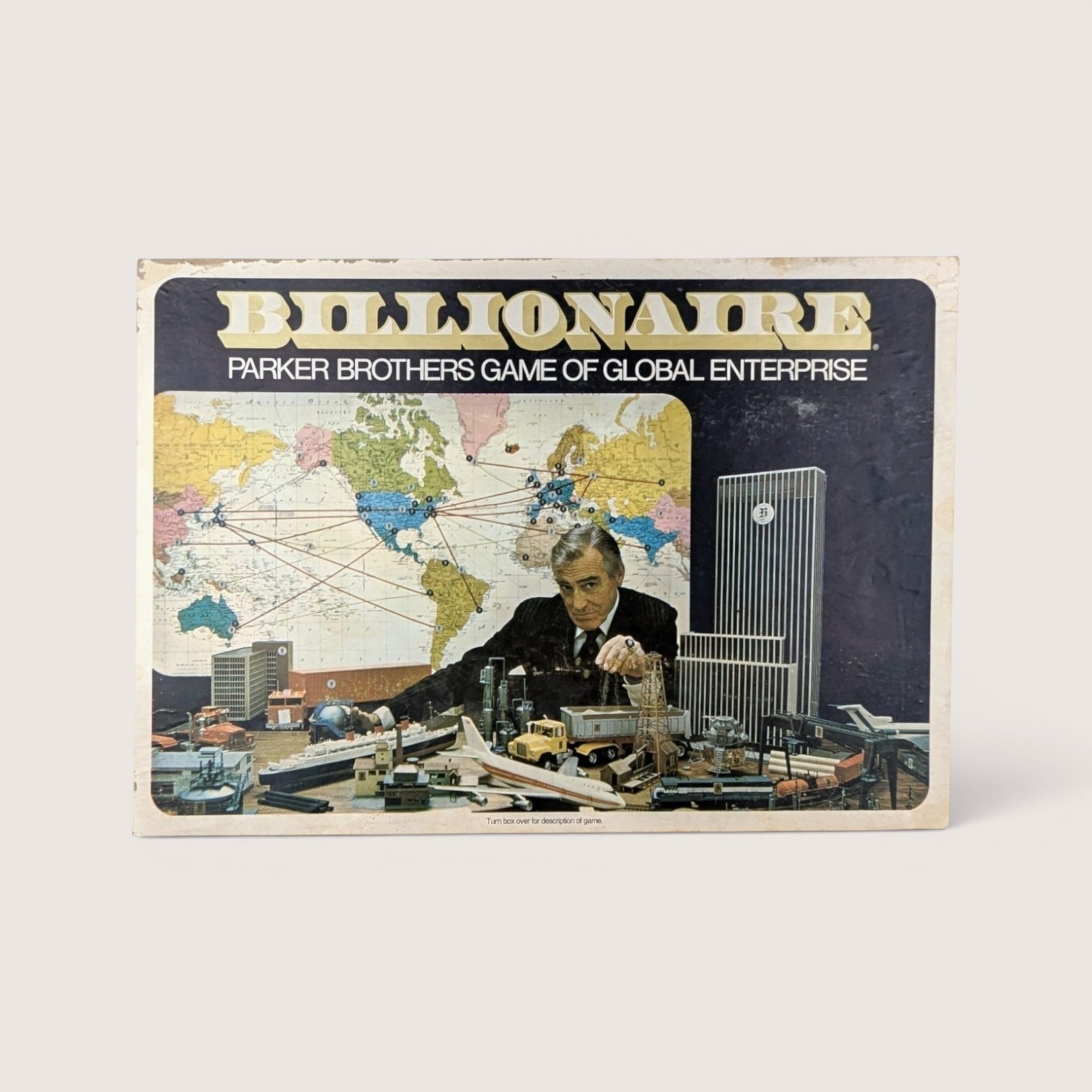 Vintage Billionaire board game box featuring a man in a suit surrounded by industrial toys and a world map.