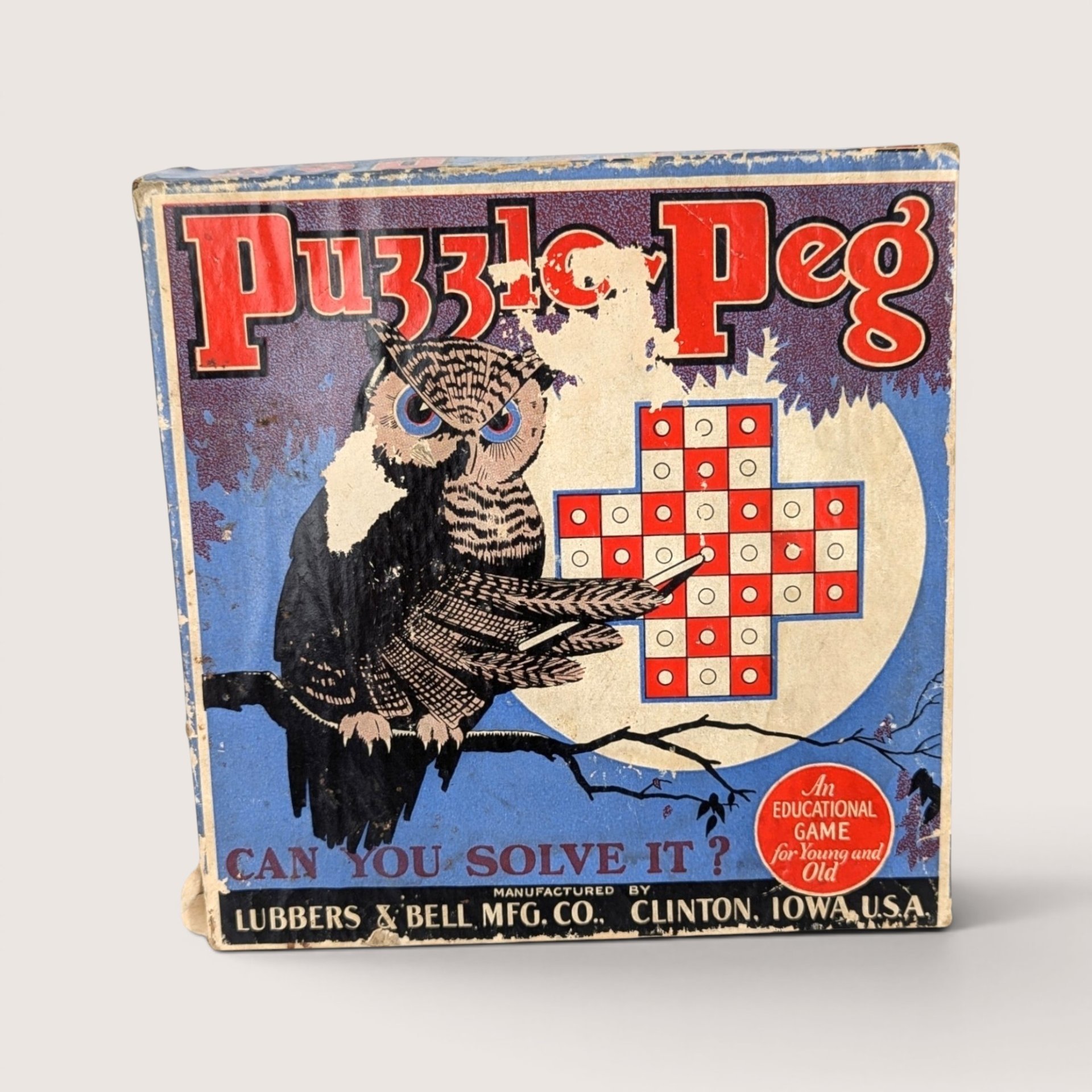Antique Puzzle Peg game box featuring a detailed illustration of an owl pointing at a cross-shaped peg board.