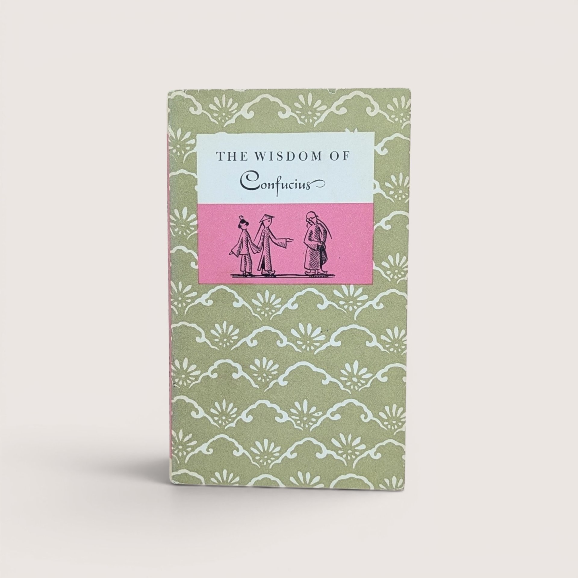 Vintage book titled The Wisdom of Confucius with a green and white patterned cover and a pink and white central label.