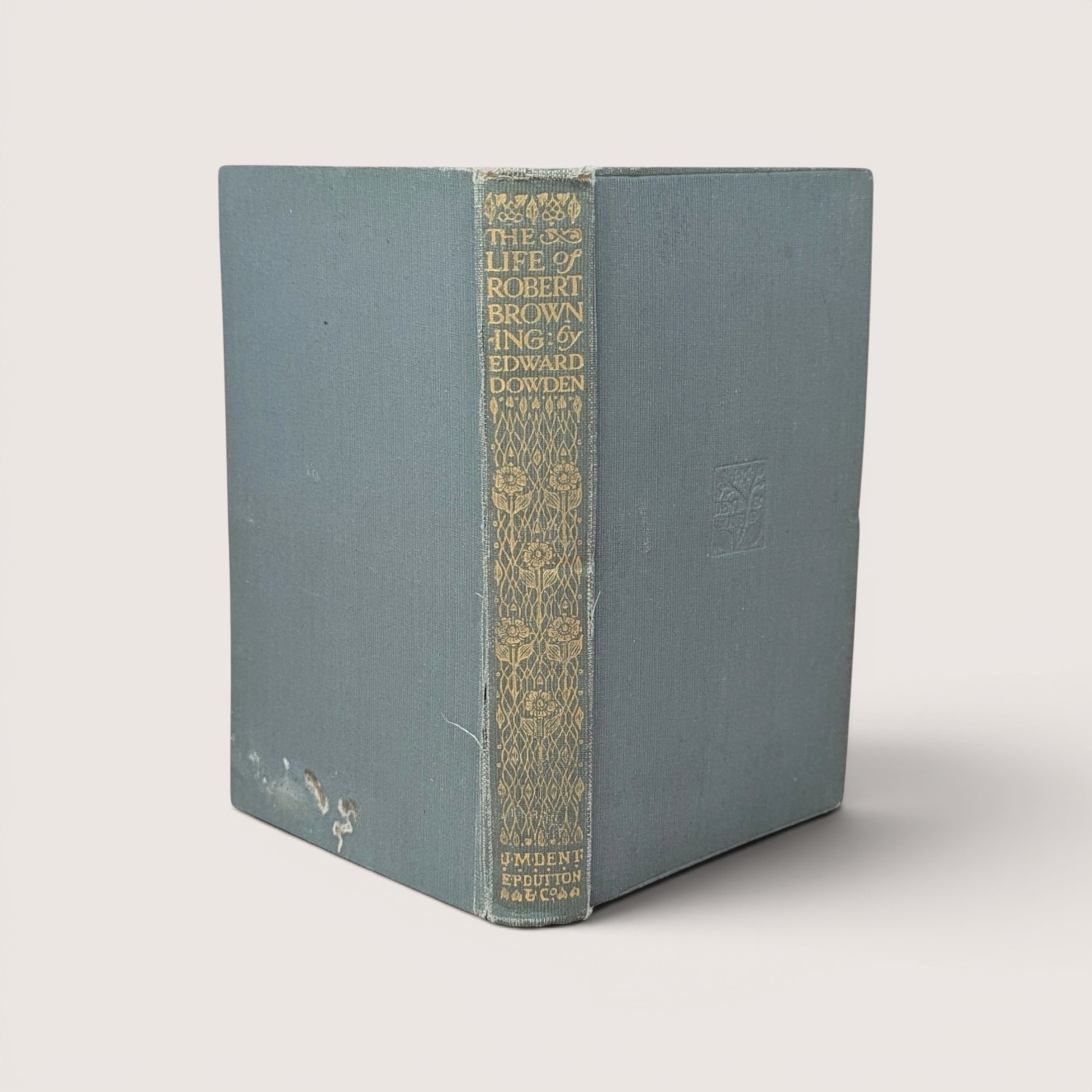 Antique book titled The Life of Robert Browning by Edward Dowden with a faded blue cloth cover and an ornate gold gilt decorated spine.