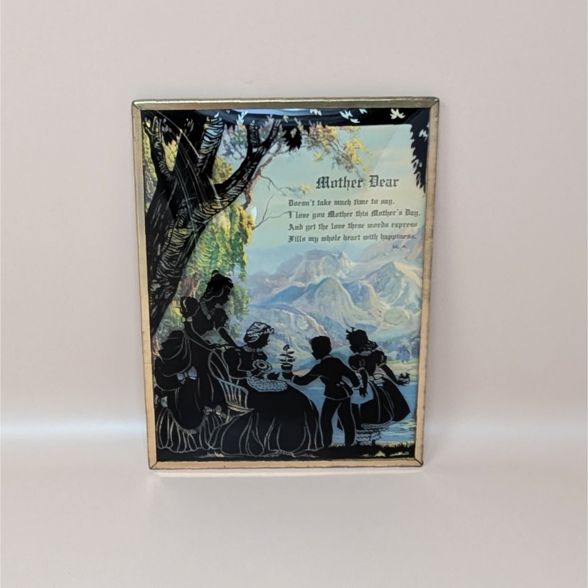 A vintage framed poem titled Mother Dear featuring black silhouette figures of a family in a mountain landscape under convex bubble glass.