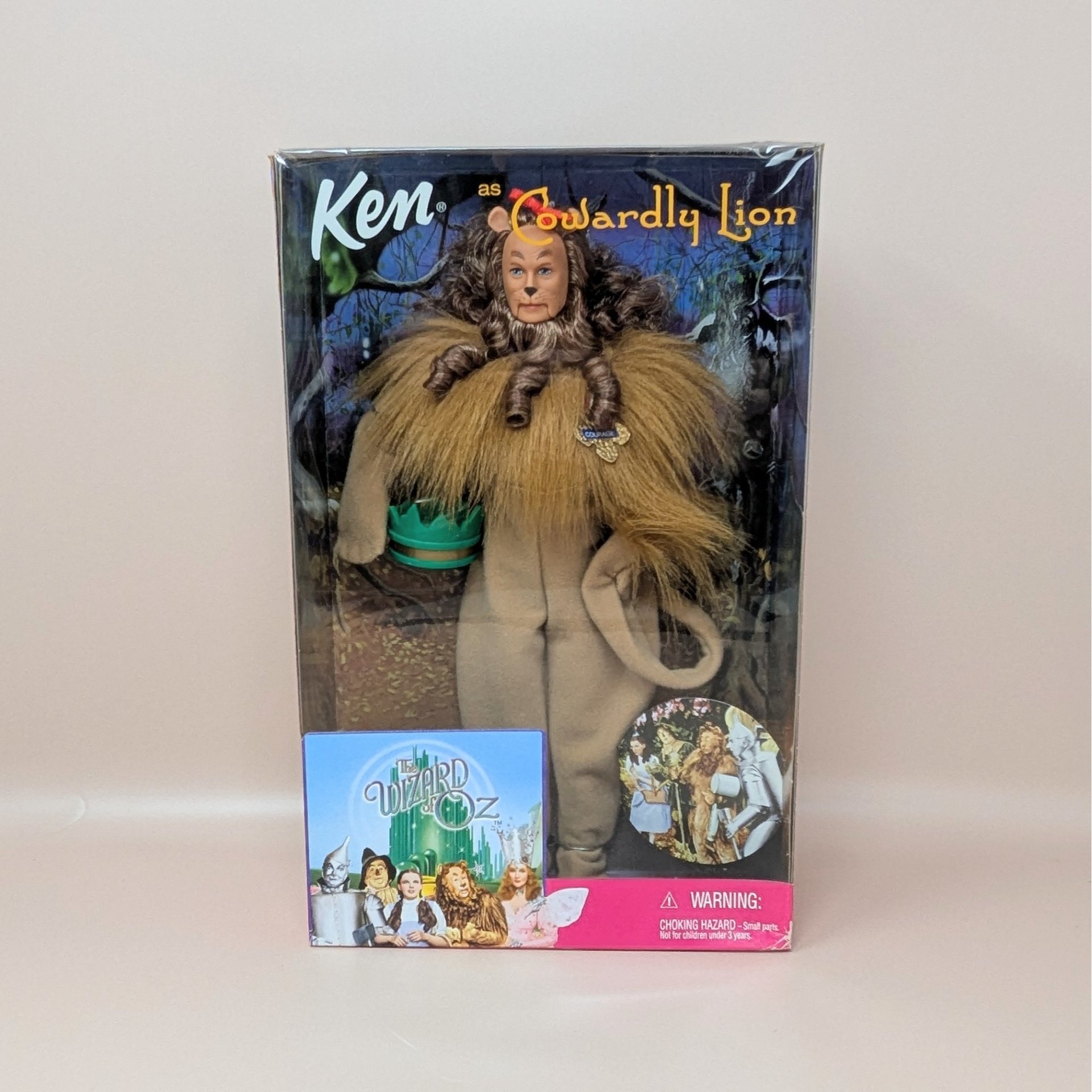 A 1999 collector edition Ken doll dressed as the Cowardly Lion from The Wizard of Oz, secured inside its original decorative character box.