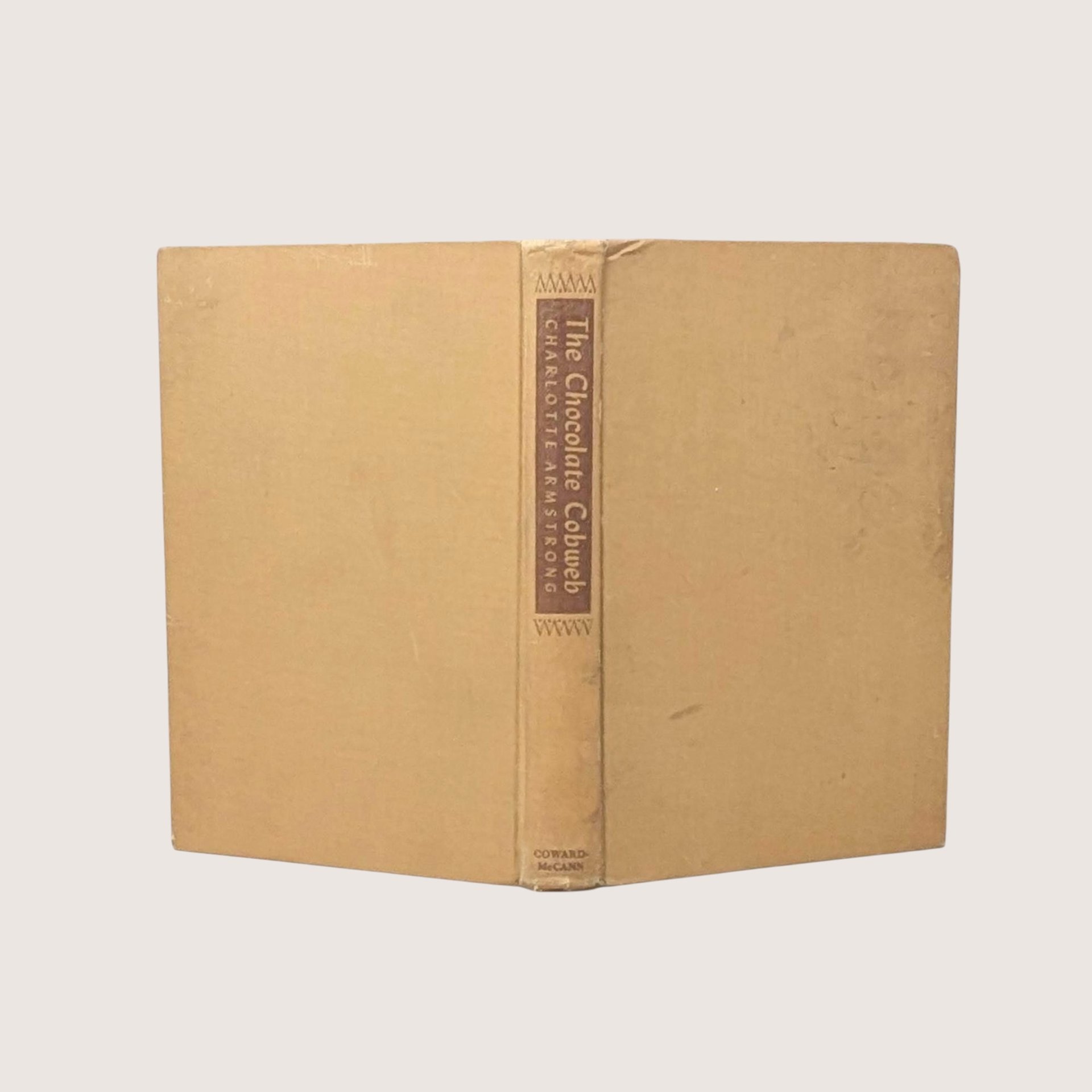 A vintage 1948 first edition hardcover of The Chocolate Cobweb by Charlotte Armstrong with a tan cloth cover and brown spine labelsA vintage 1948 first edition hardcover of The Chocolate Cobweb by Charlotte Armstrong with a tan cloth cover and brown spine labels
