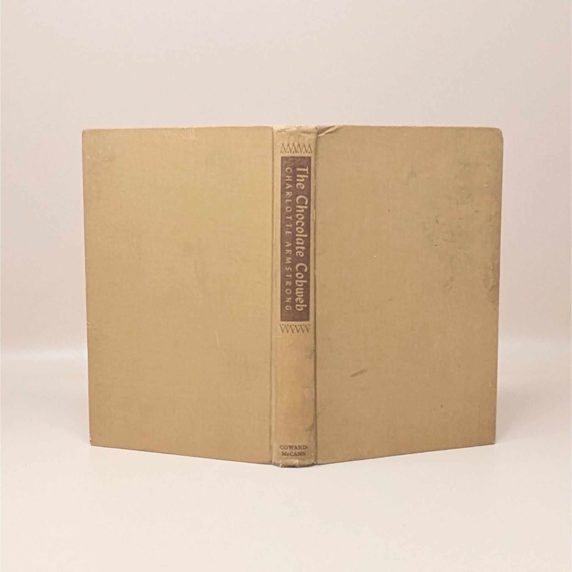 A vintage 1948 first edition hardcover of The Chocolate Cobweb by Charlotte Armstrong with a tan cloth cover and brown spine labelsA vintage 1948 first edition hardcover of The Chocolate Cobweb by Charlotte Armstrong with a tan cloth cover and brown spine labels
