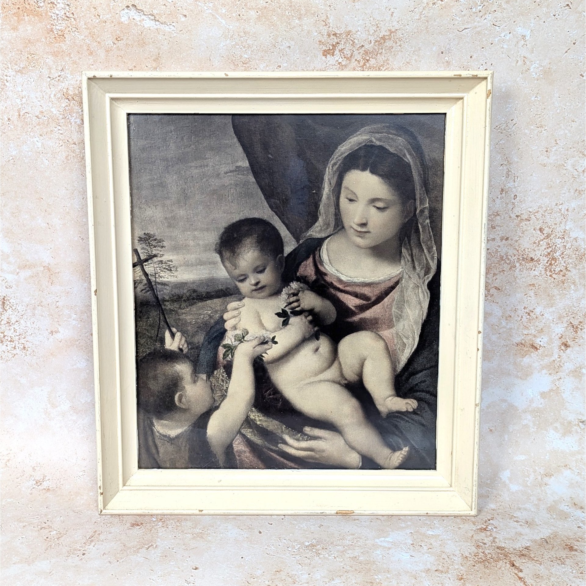 A rare vintage 1950s framed print of Titian's Madonna and Child on a tan textured background. The classic Renaissance lithograph is housed behind glass in a heavy, distressed ivory painted wood frame showing natural age scuffs.