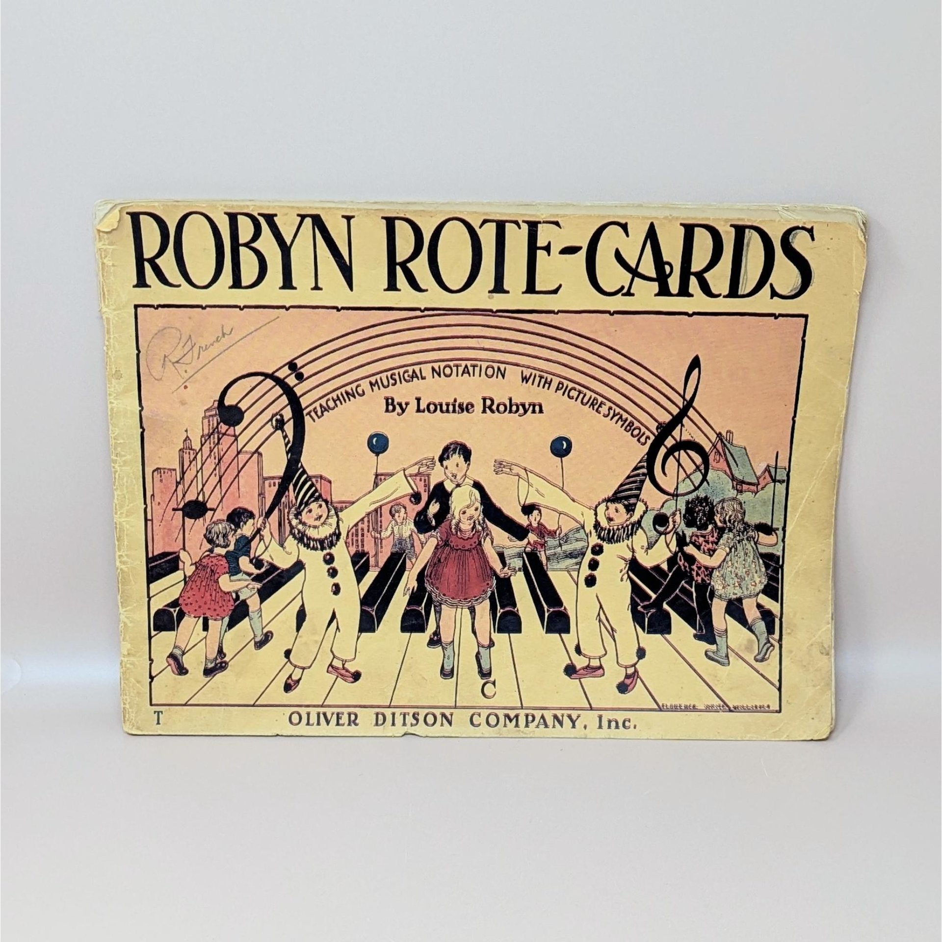 A vintage 1935 softcover music book titled Robyn Rote-Cards featuring a colorful illustration of children and clowns on a piano keyboard