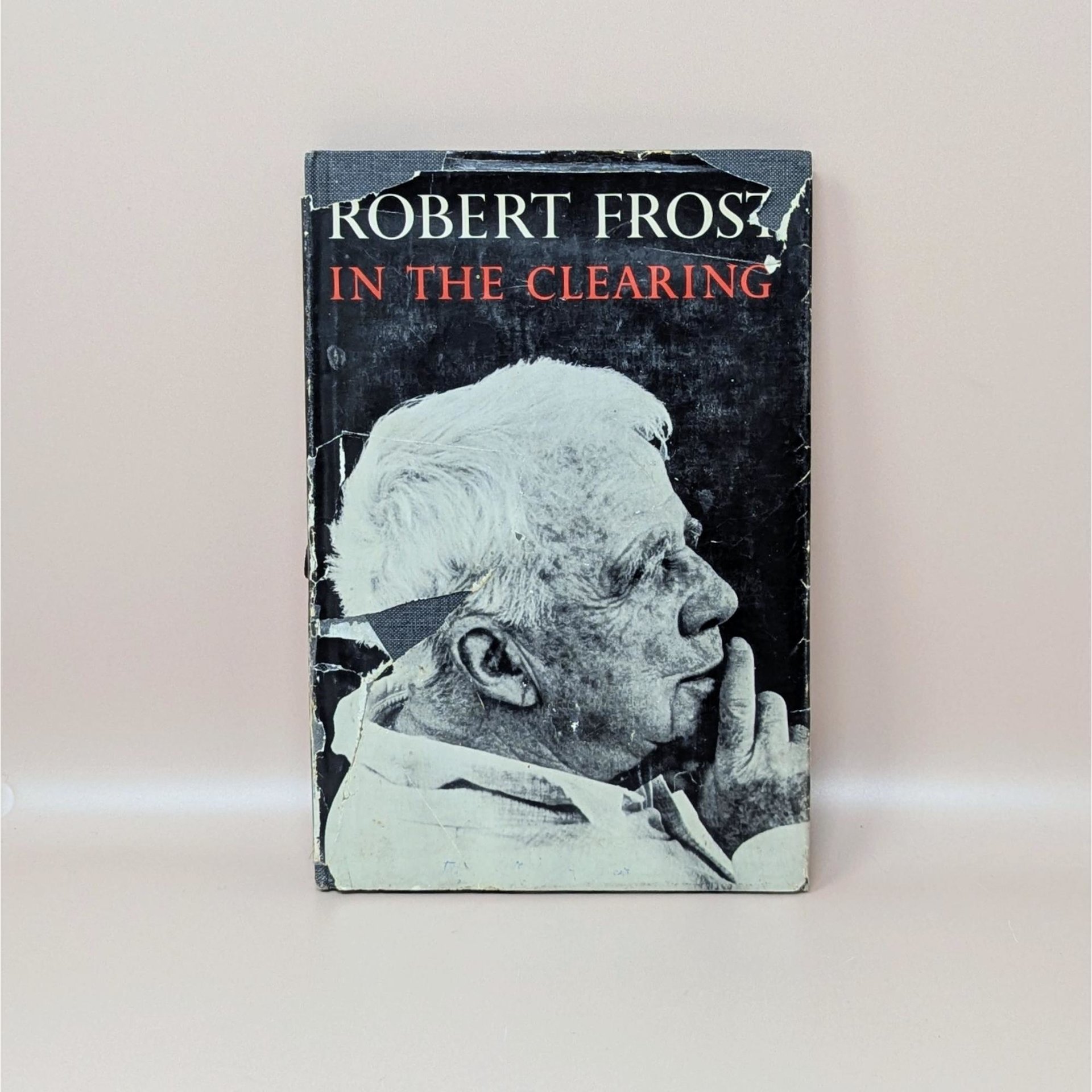 A vintage hardcover edition of In the Clearing by Robert Frost featuring a black and white portrait of the poet on a worn dust jacket