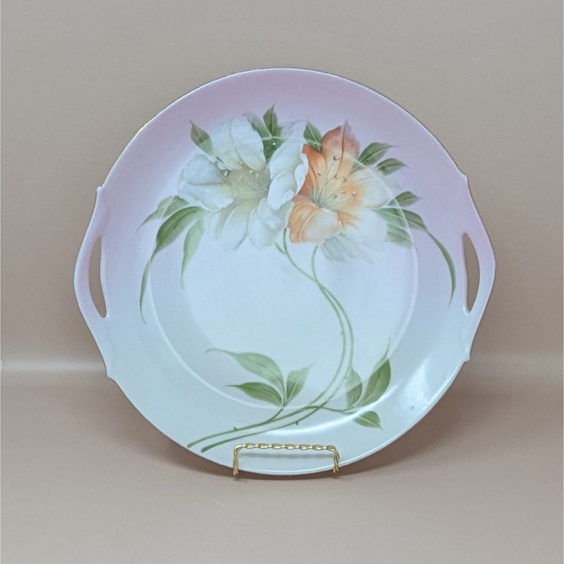 A vintage large porcelain plate from Z.S. & C. Bavaria featuring hand-painted white and orange lilies with a soft pink gradient rim and gold accents.