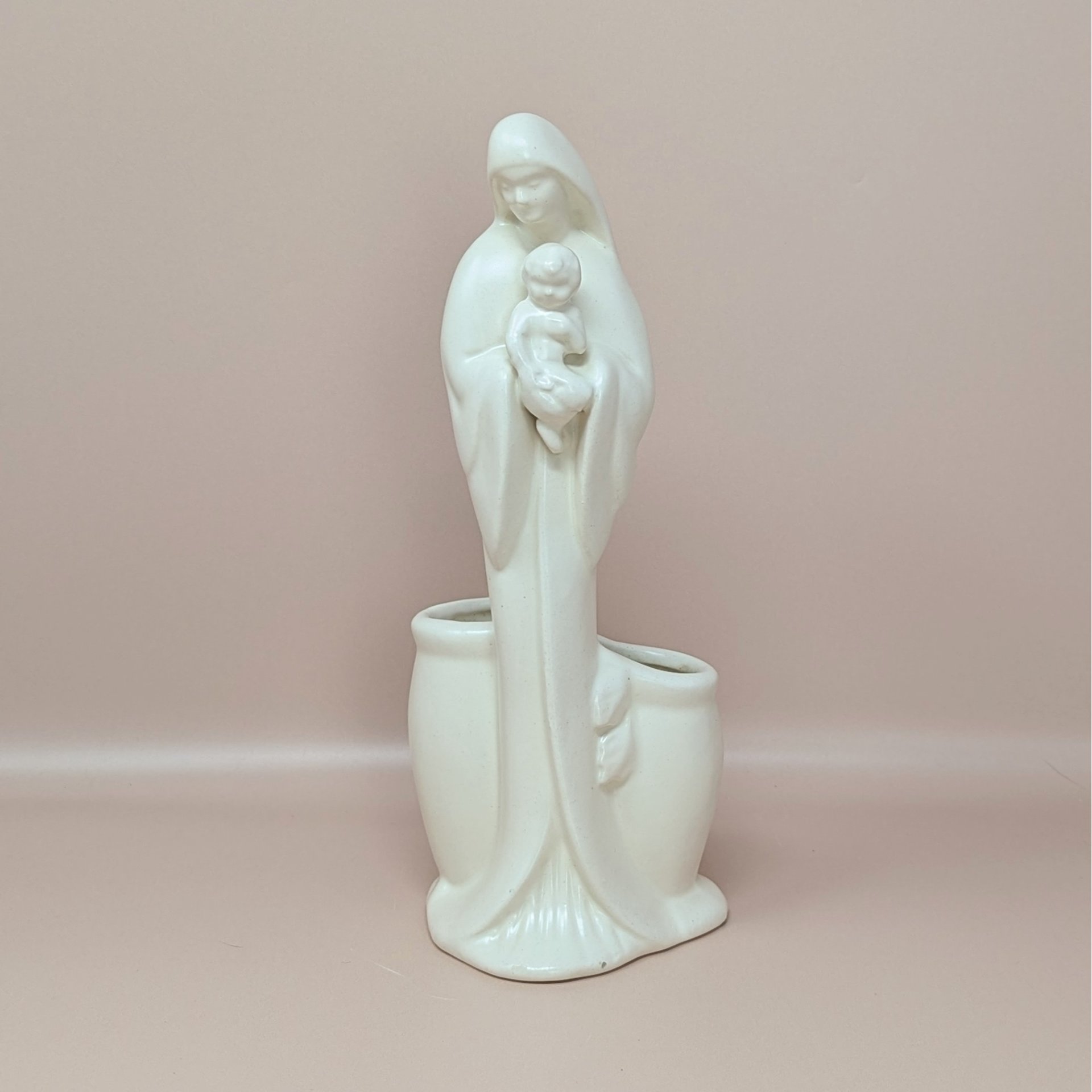 A vintage cream-colored Haeger Madonna and Child ceramic planter standing against a neutral background