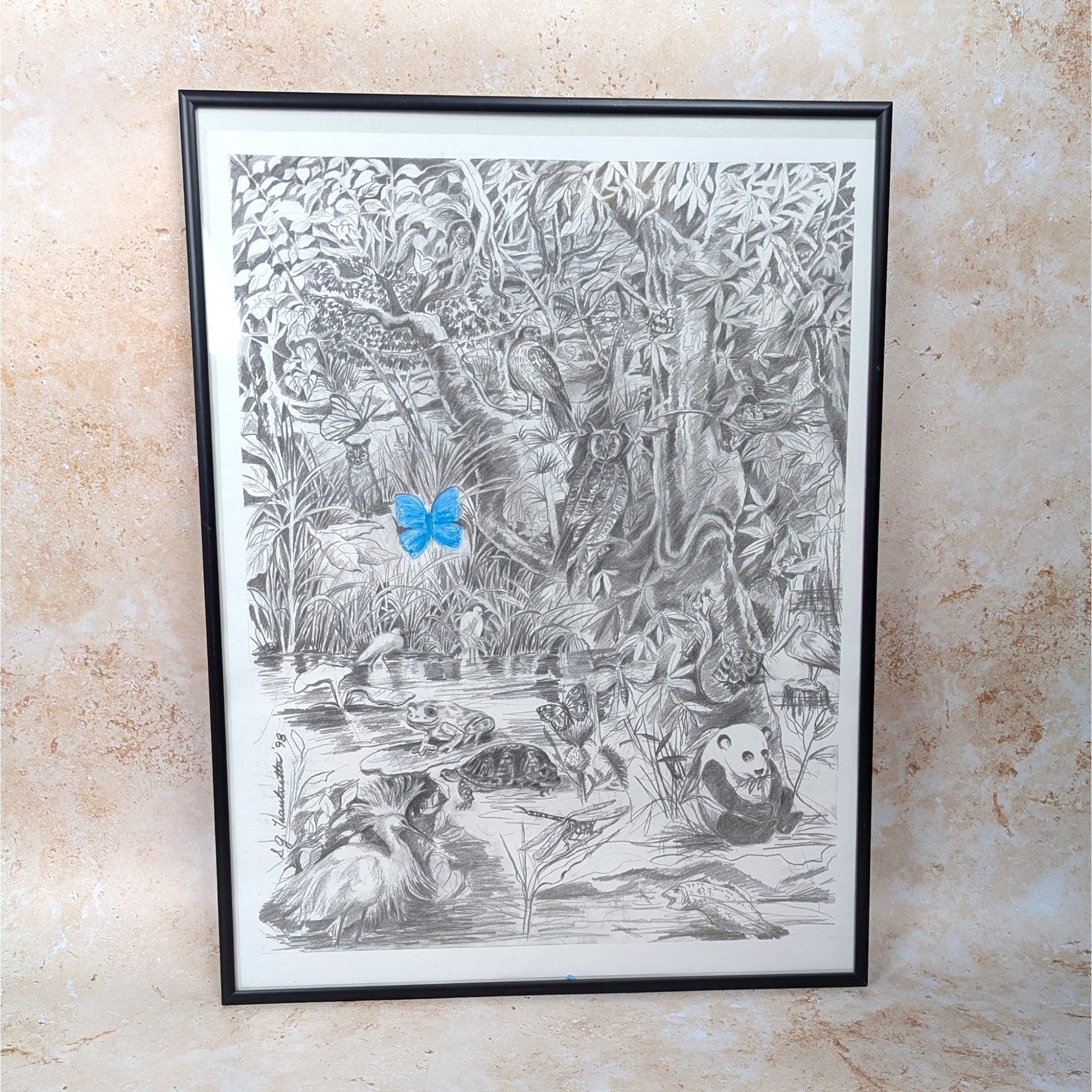 A 1998 vintage framed nature drawing print on a tan textured background. The large black and white sketch depicts a dense jungle filled with animals like a panda, owl, and turtle, accented by a single bright blue colored butterfly.