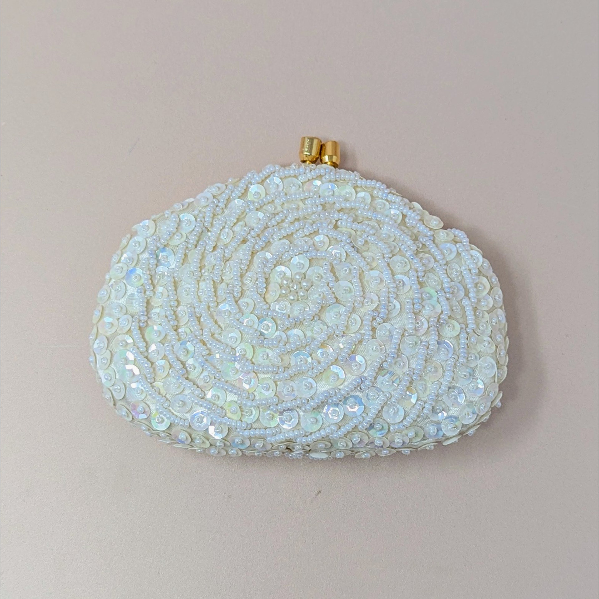 A vintage cream-colored coin purse in file C2040 3.jpg covered in intricate swirls of iridescent sequins and small white beads with a gold kiss-lock closure