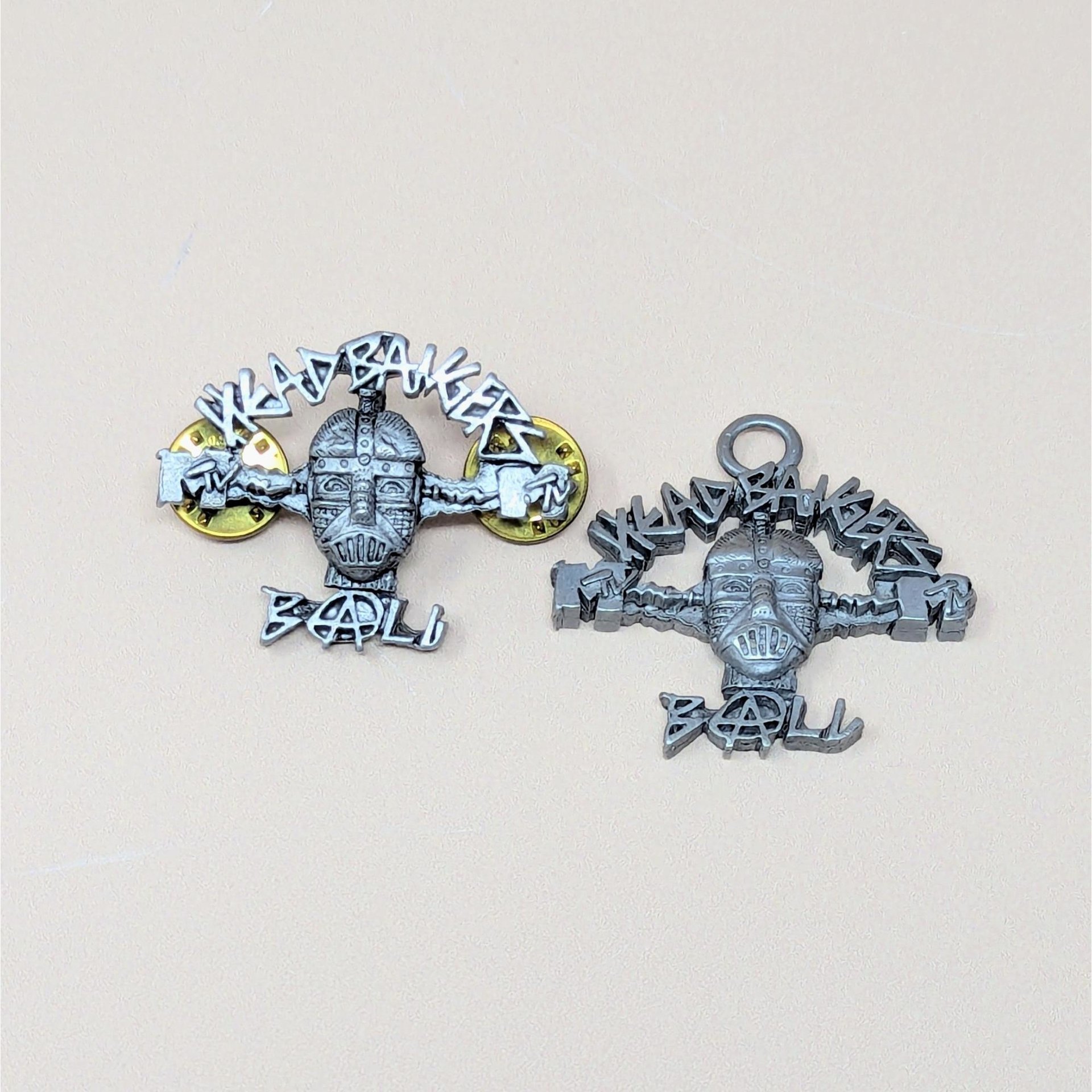 A pair of 1993 pewter MTV Headbangers Ball accessories including a lapel pin with two gold butterfly clutches and a pendant with a top loop
