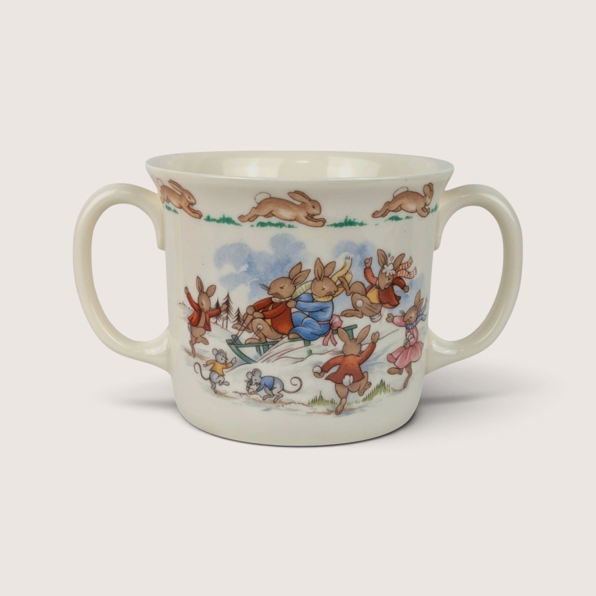 Vintage Royal Doulton Bunnykins fine bone china two-handle mug featuring a sledding motif.