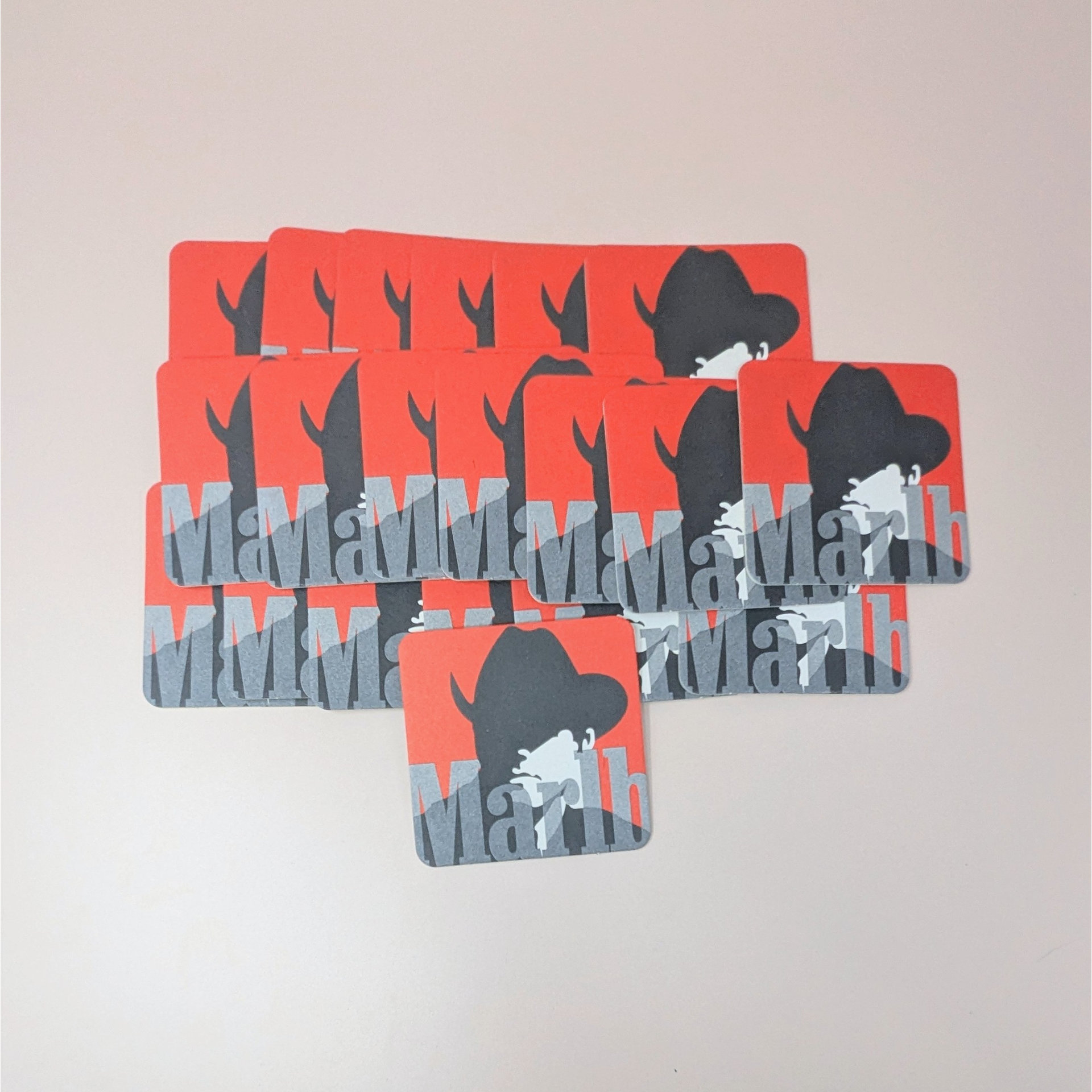 A fan of 20 square cardboard coasters featuring the iconic Marlboro Man cowboy silhouette in black and white against a bold red background with gray Marlboro text.