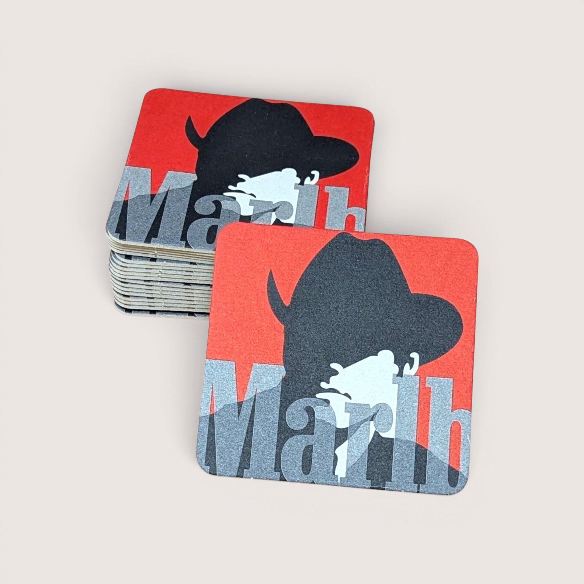 A stack of square cardboard coasters showing the iconic black cowboy silhouette on a red background.