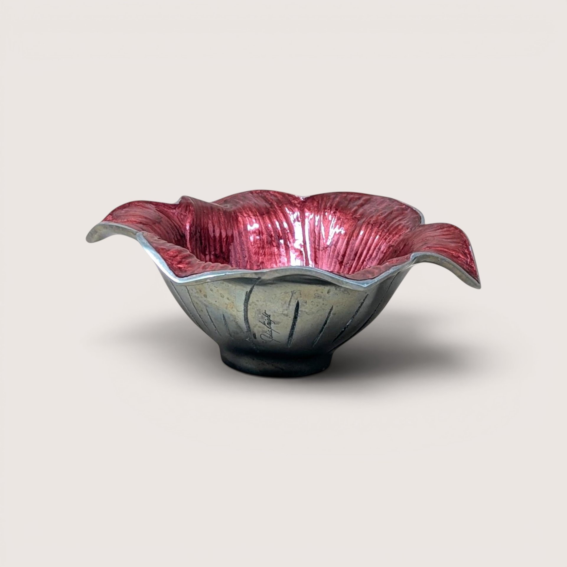 A sand-cast aluminum lily flower bowl with a glossy, jewel-toned raspberry pink enamel interior on a plain background.