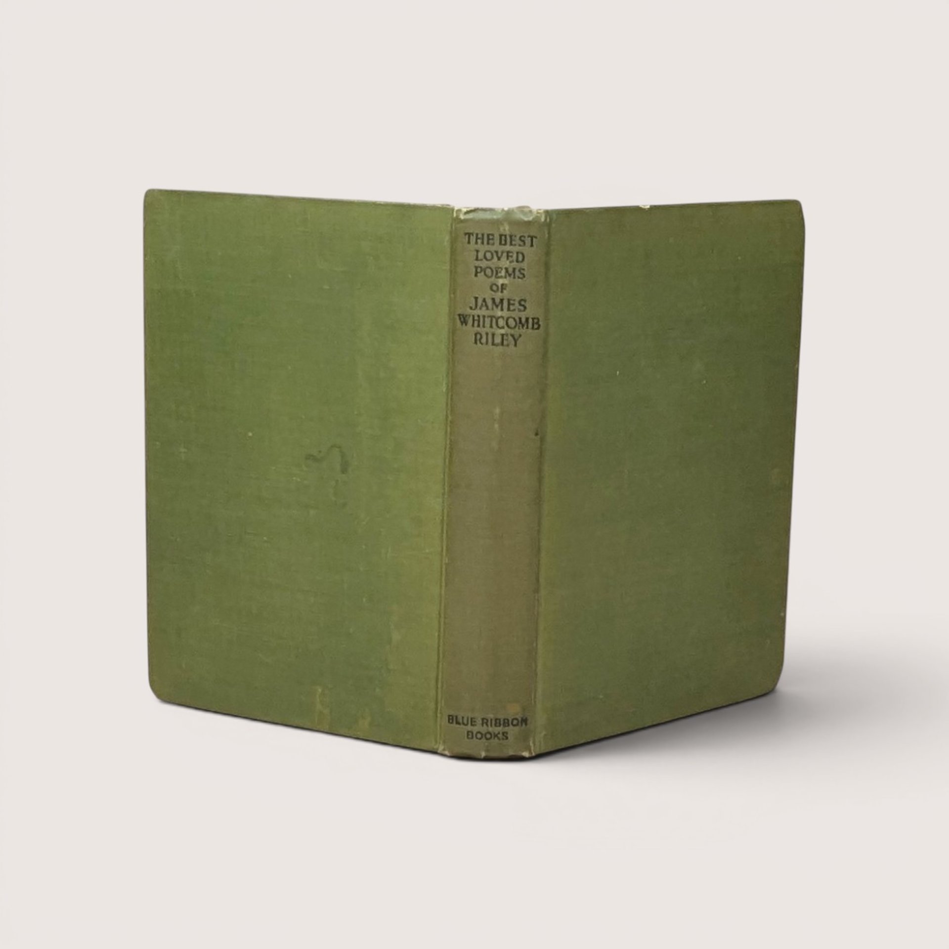 A vintage green cloth hardcover book spine and boards standing upright against a neutral backdrop