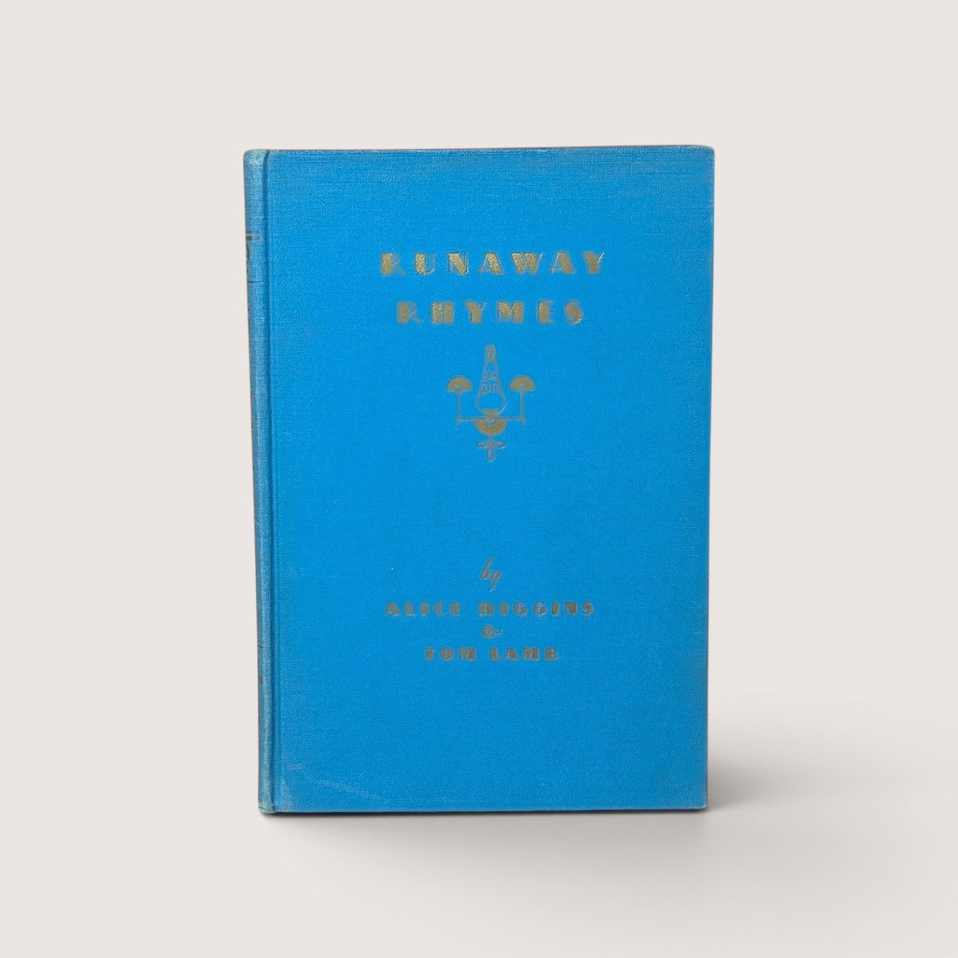 An antique bright blue cloth hardcover book with gold gilt text and a small candle emblem on the front cover
