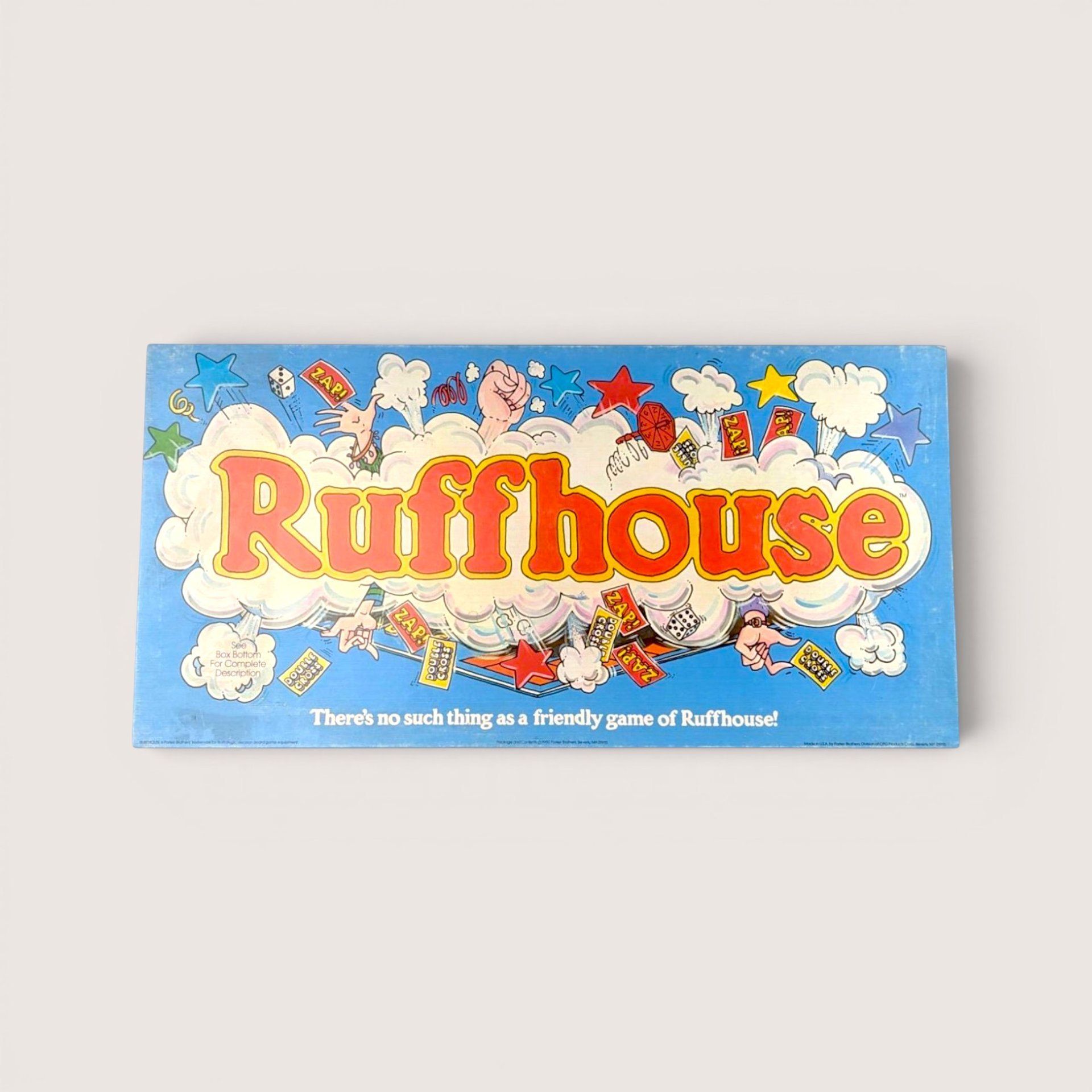 Vintage Ruffhouse board game box in light blue with bubble letters surrounded by comic book style action explosions.