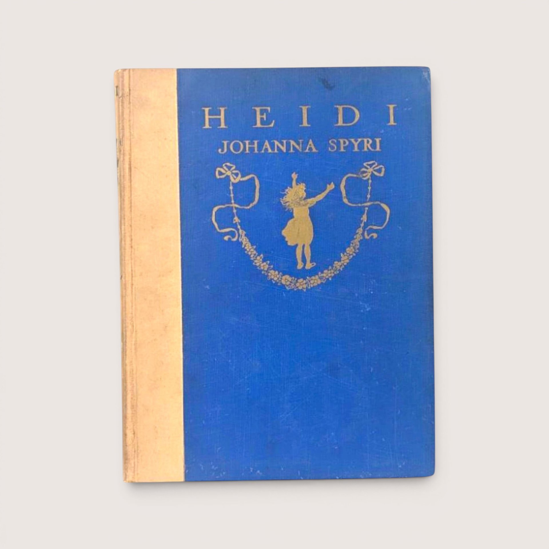 Antique 1919 hardcover edition of Heidi by Johanna Spyri featuring a blue cloth cover with gold gilt illustrations