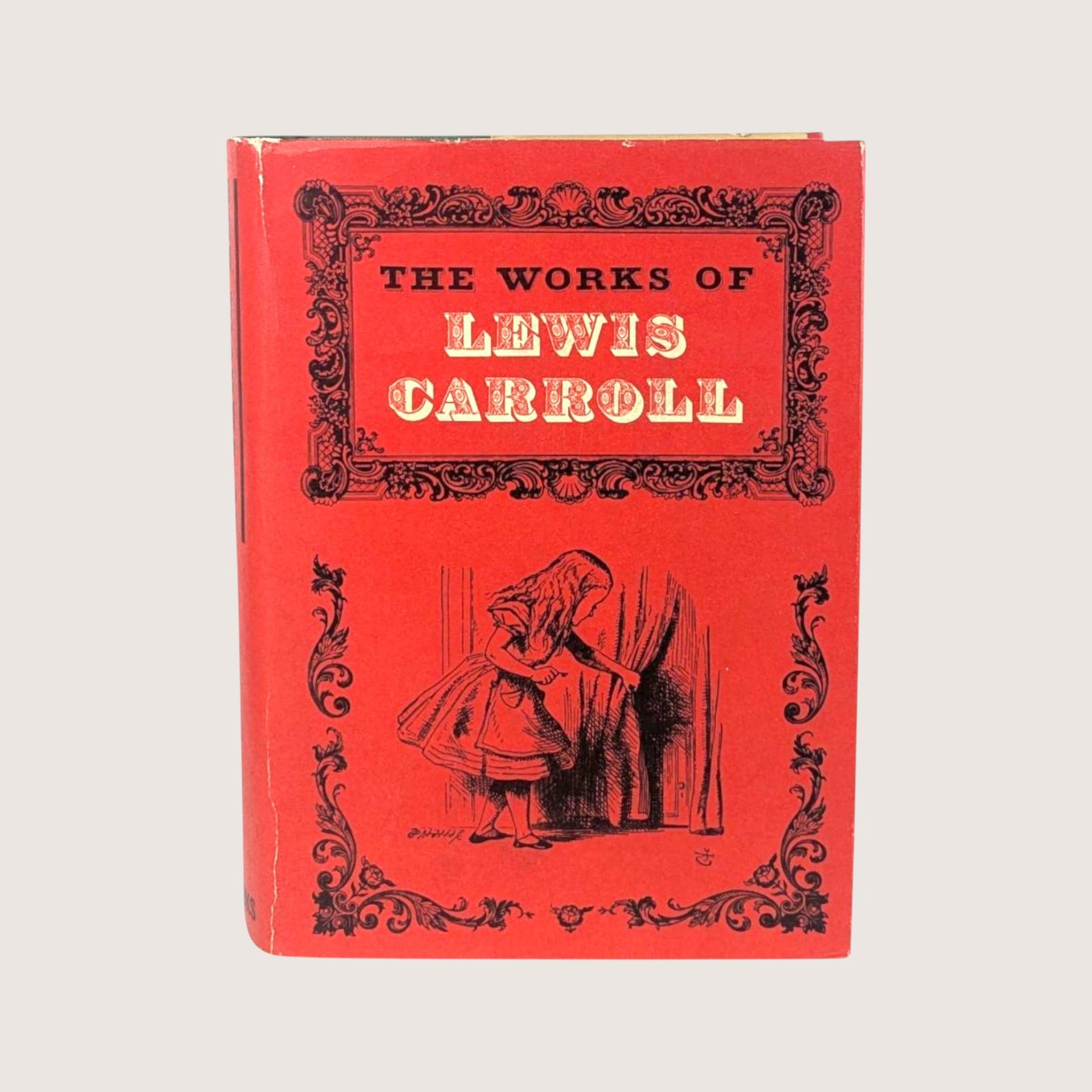 A vintage 1965 hardcover edition of The Works of Lewis Carroll with a vibrant red illustrated dust jacket.