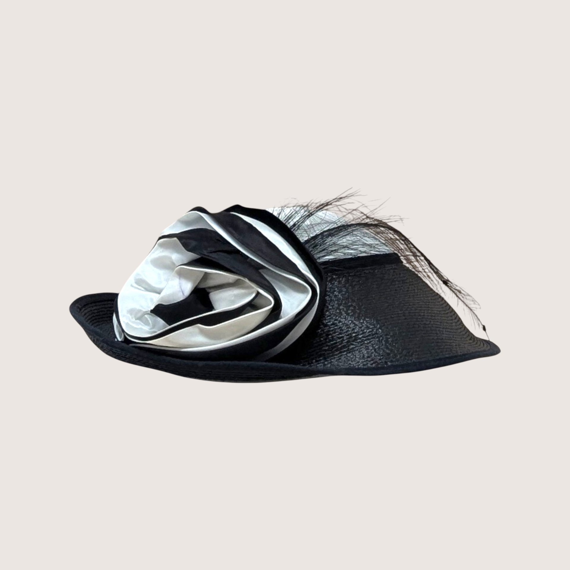 A vintage Jody G for Sylvia black and white straw hat featuring a large matching fabric rosette on the side.