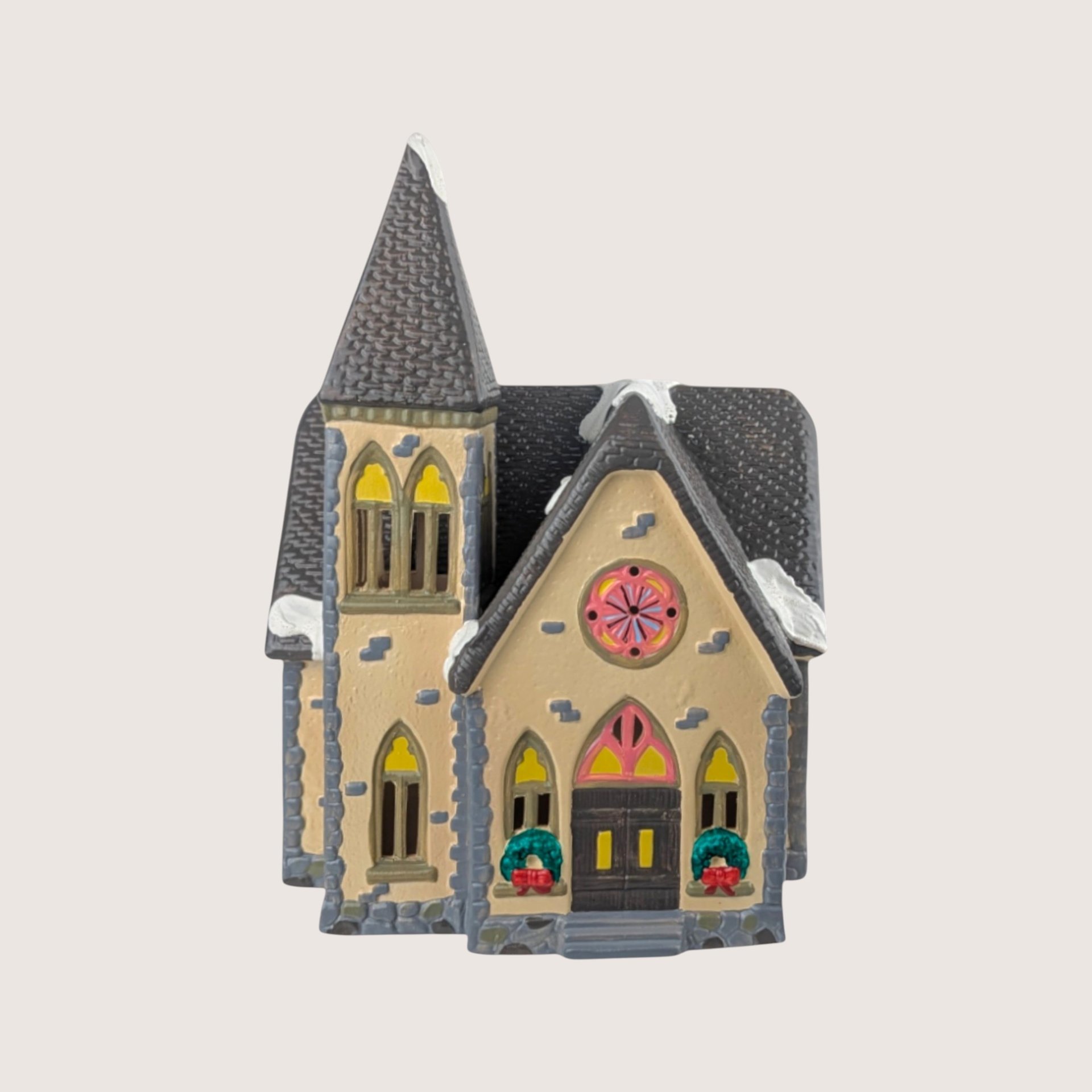 A vintage 1988 Department 56 Snow Village ceramic building titled Redeemer Church with an ornate steeple and gothic windows.
