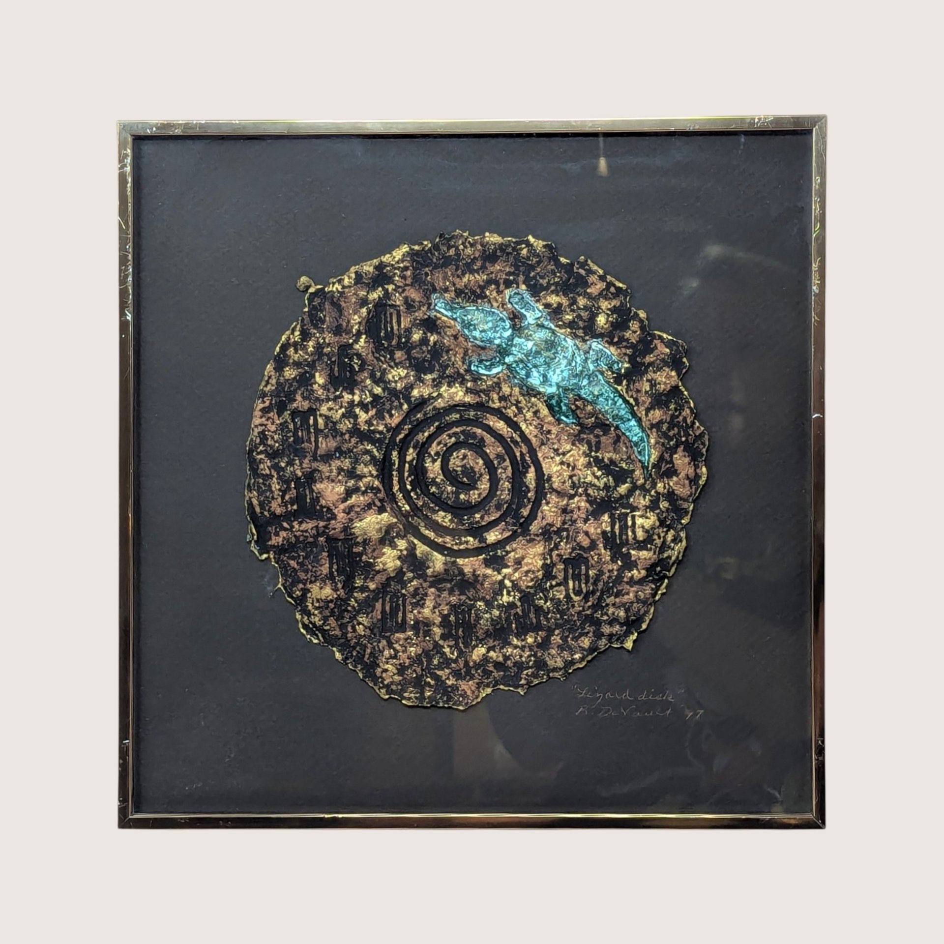 A framed 1997 mixed media painting by Barbara DeVault titled Lizard Disk featuring a textured paper medallion with a blue lizard.