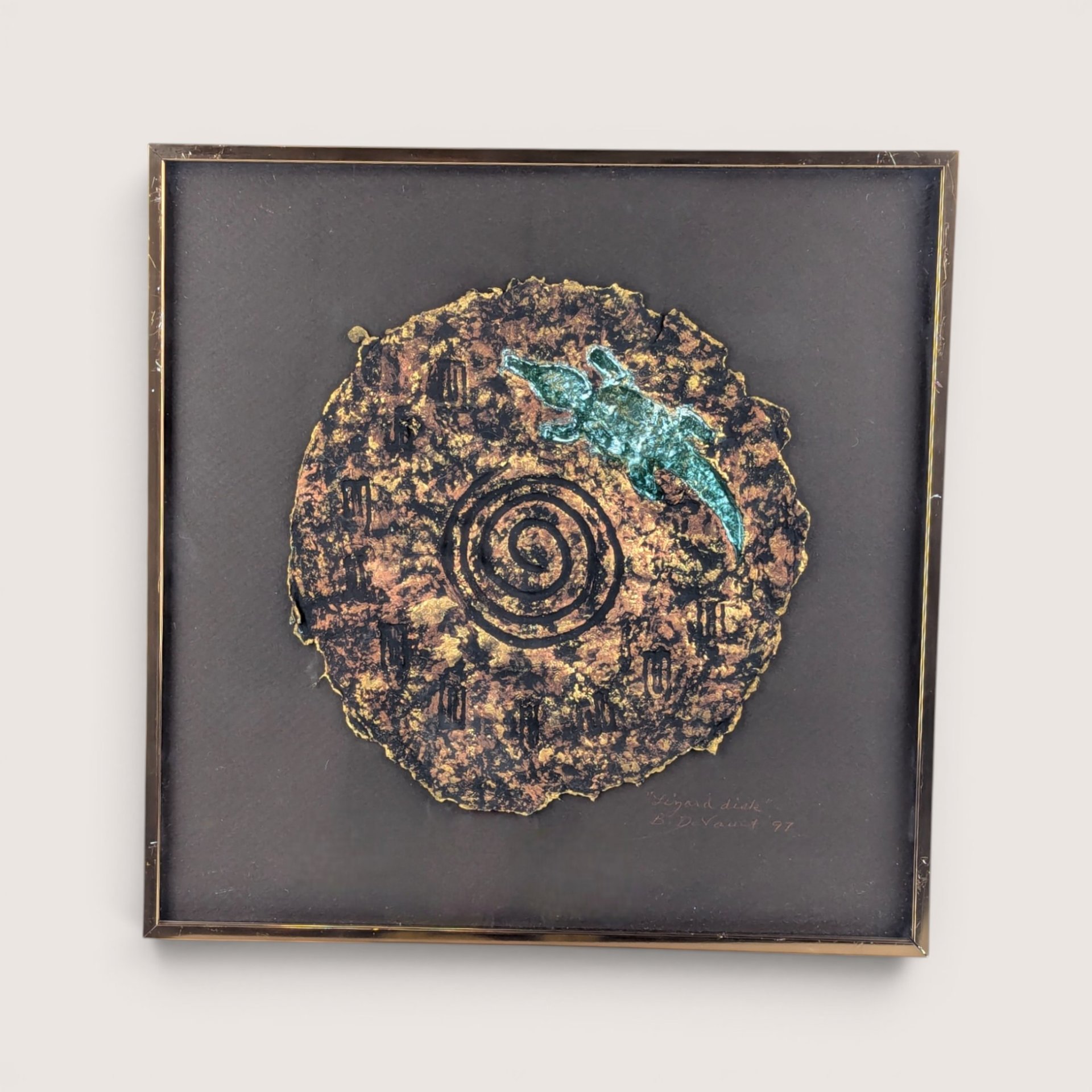 A framed 1997 mixed media painting by Barbara DeVault titled Lizard Disk featuring a textured paper medallion with a blue lizard.