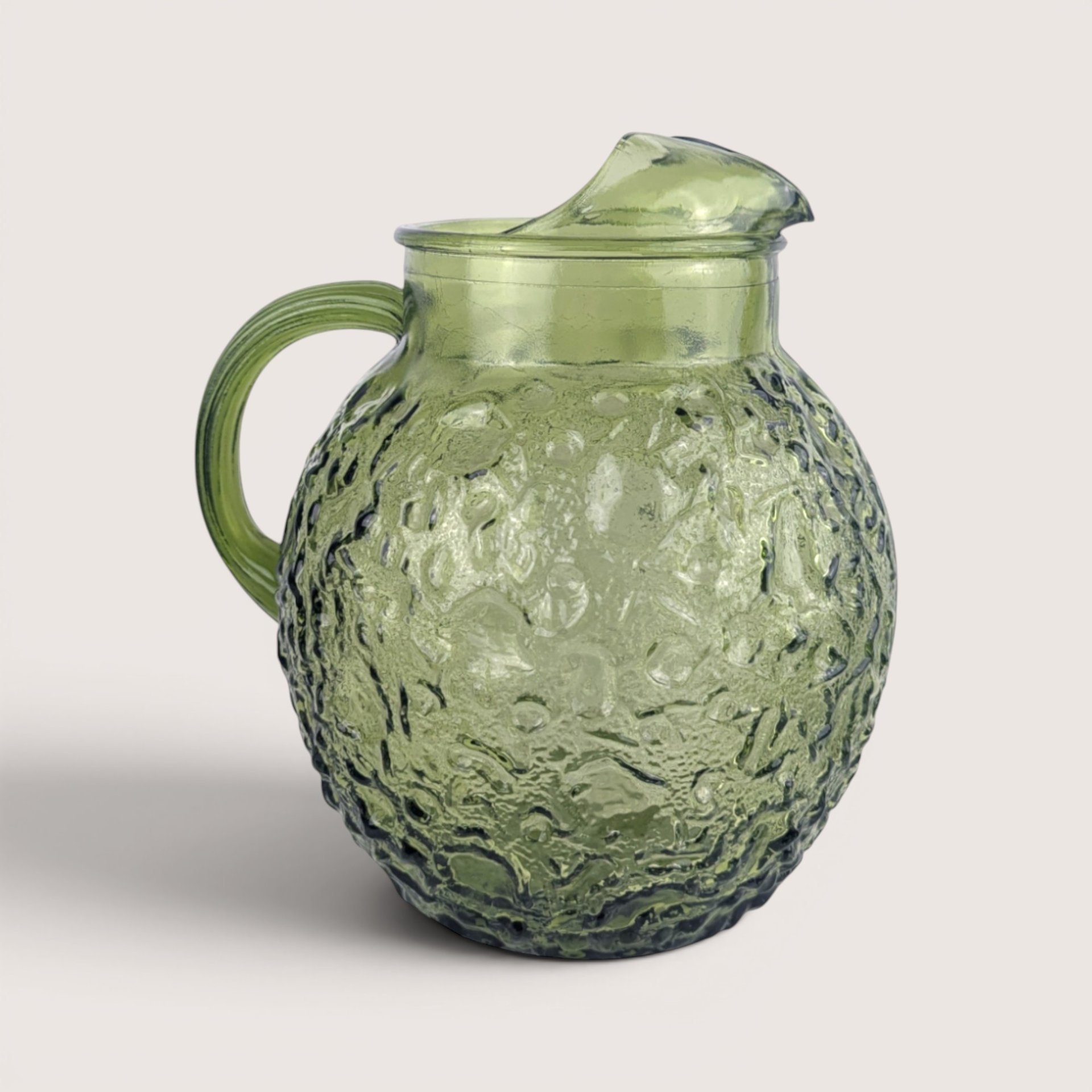 Vintage Anchor Hocking forest green textured glass pitcher with a curved handle and ice lip.