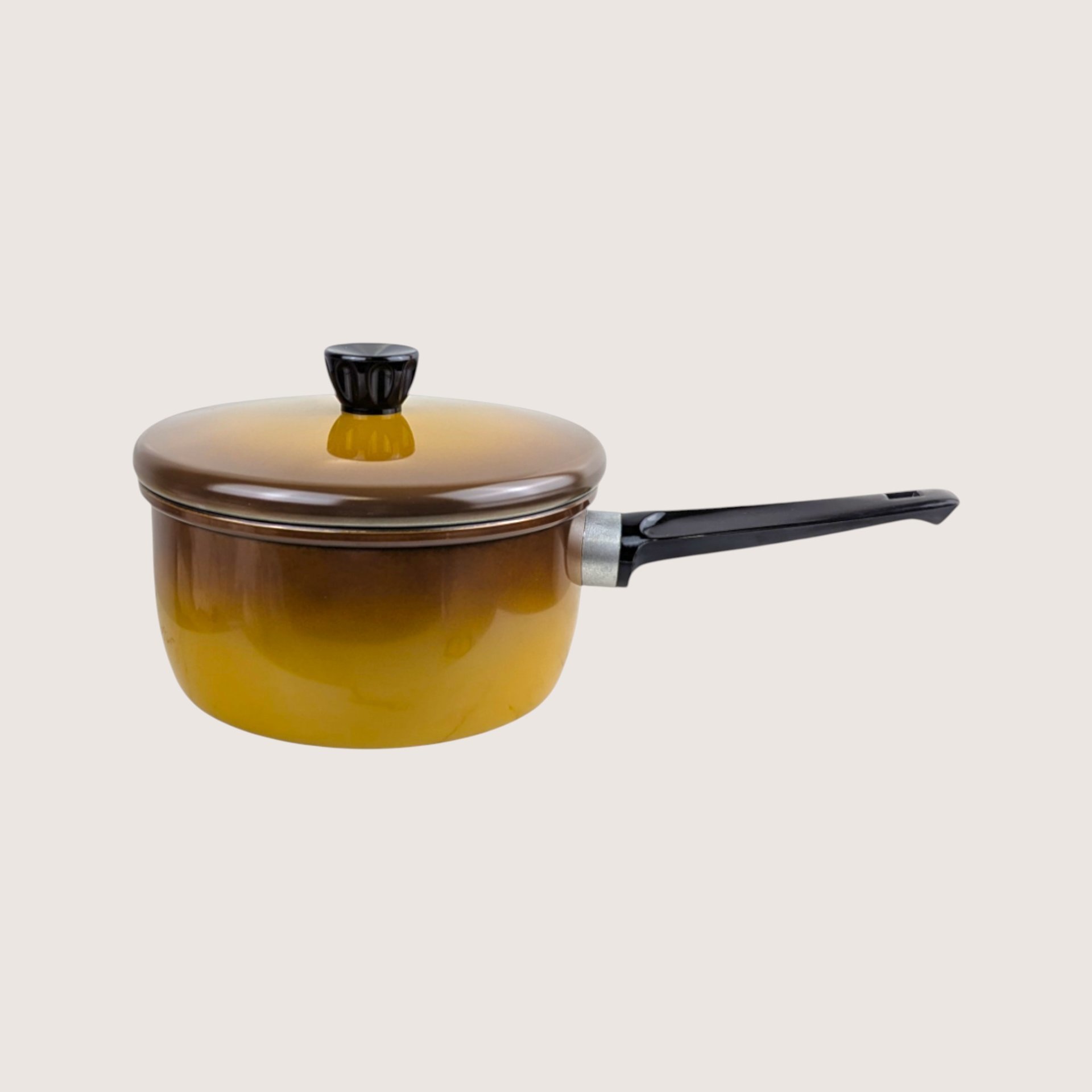 Vintage Revere Ware brown ombre enamel 2 quart sauce pan with lid on a plain light background.