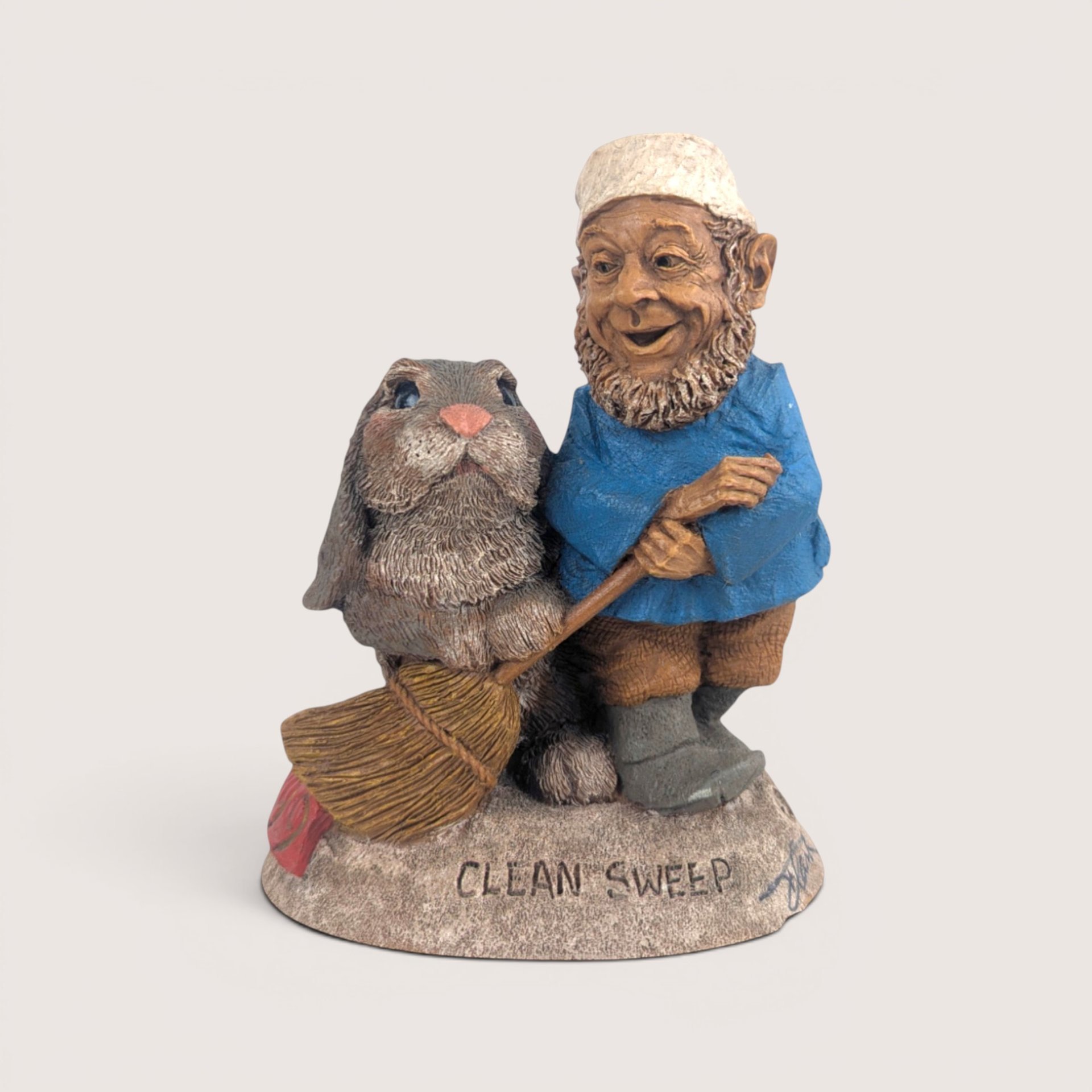 A vintage Tom Clark Cairn Studios resin gnome figurine titled Clean Sweep featuring a gnome holding a broom next to a rabbit.