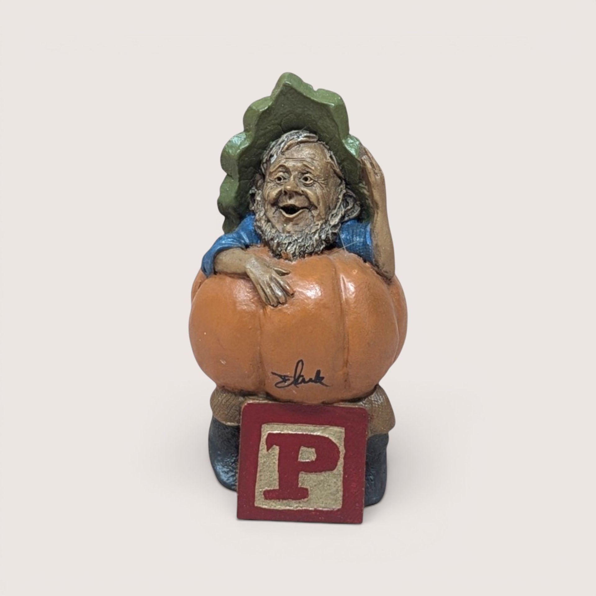 1991 Tom Clark signed Peter pumpkin gnome figurine sitting on a red alphabet letter P block on a linen background