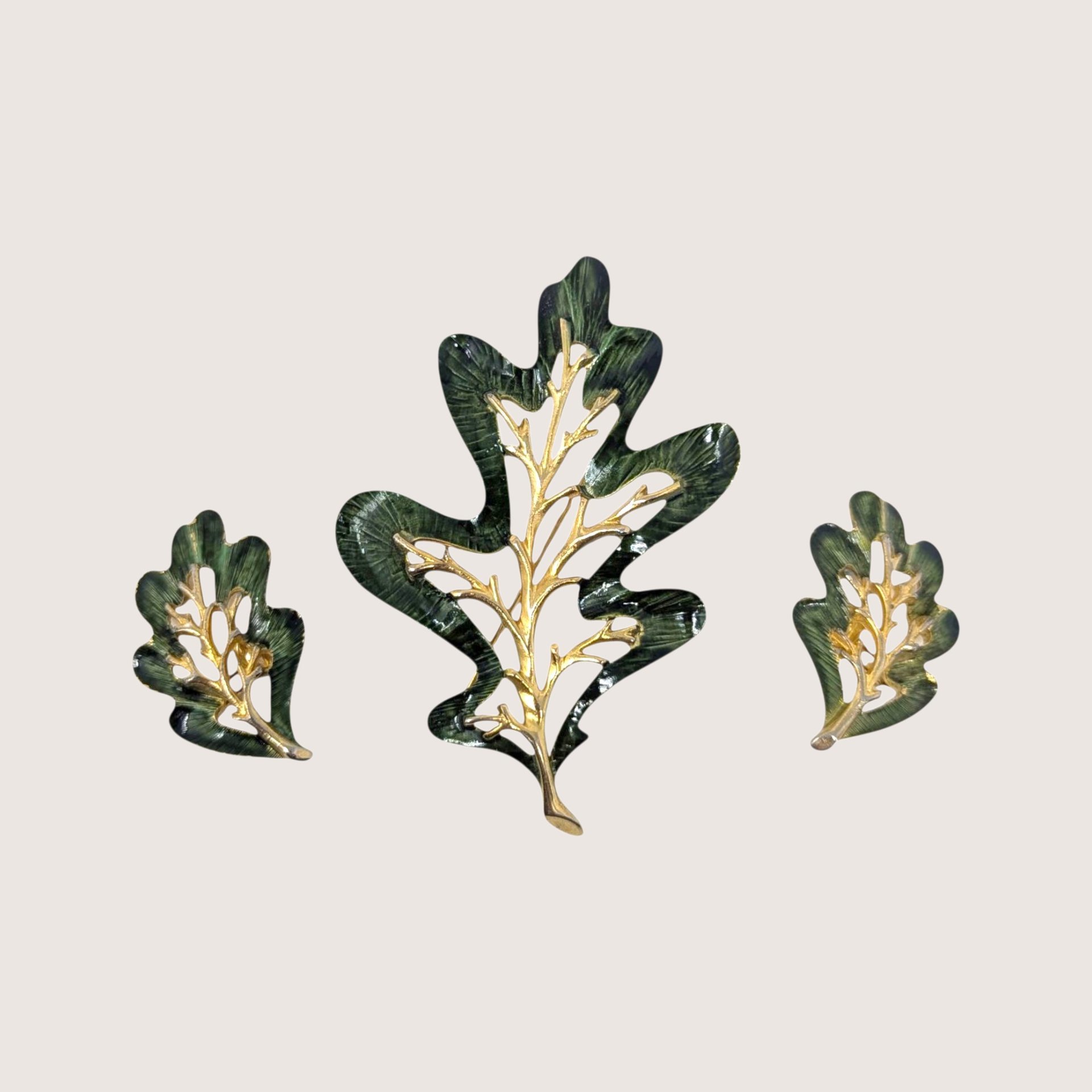 Vintage Sarah Coventry Enchanted Forest green enamel oak leaf brooch and clip on earrings set on a linen background
