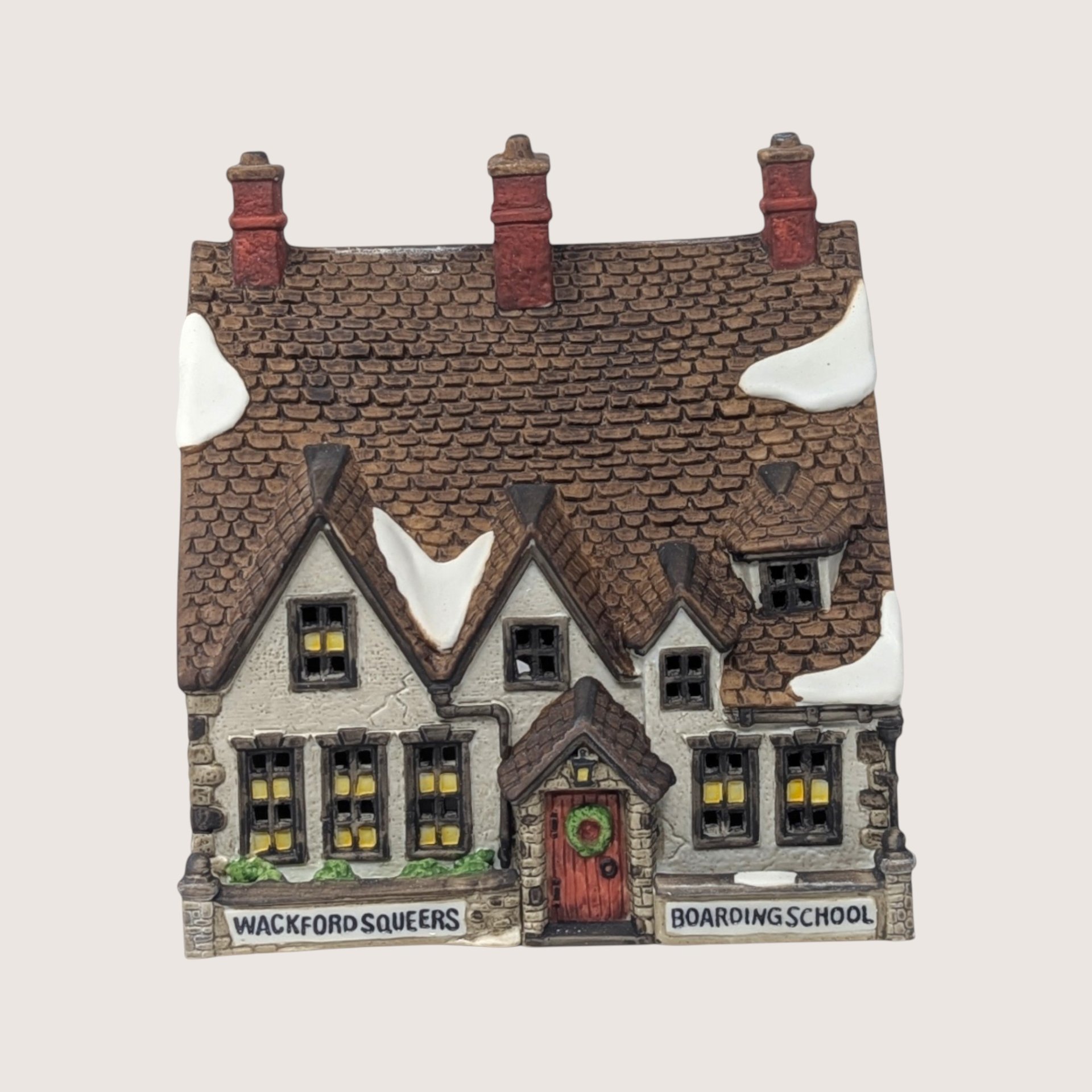 A handpainted porcelain Dept 56 Wackford Squeers Boarding School building on a linen background