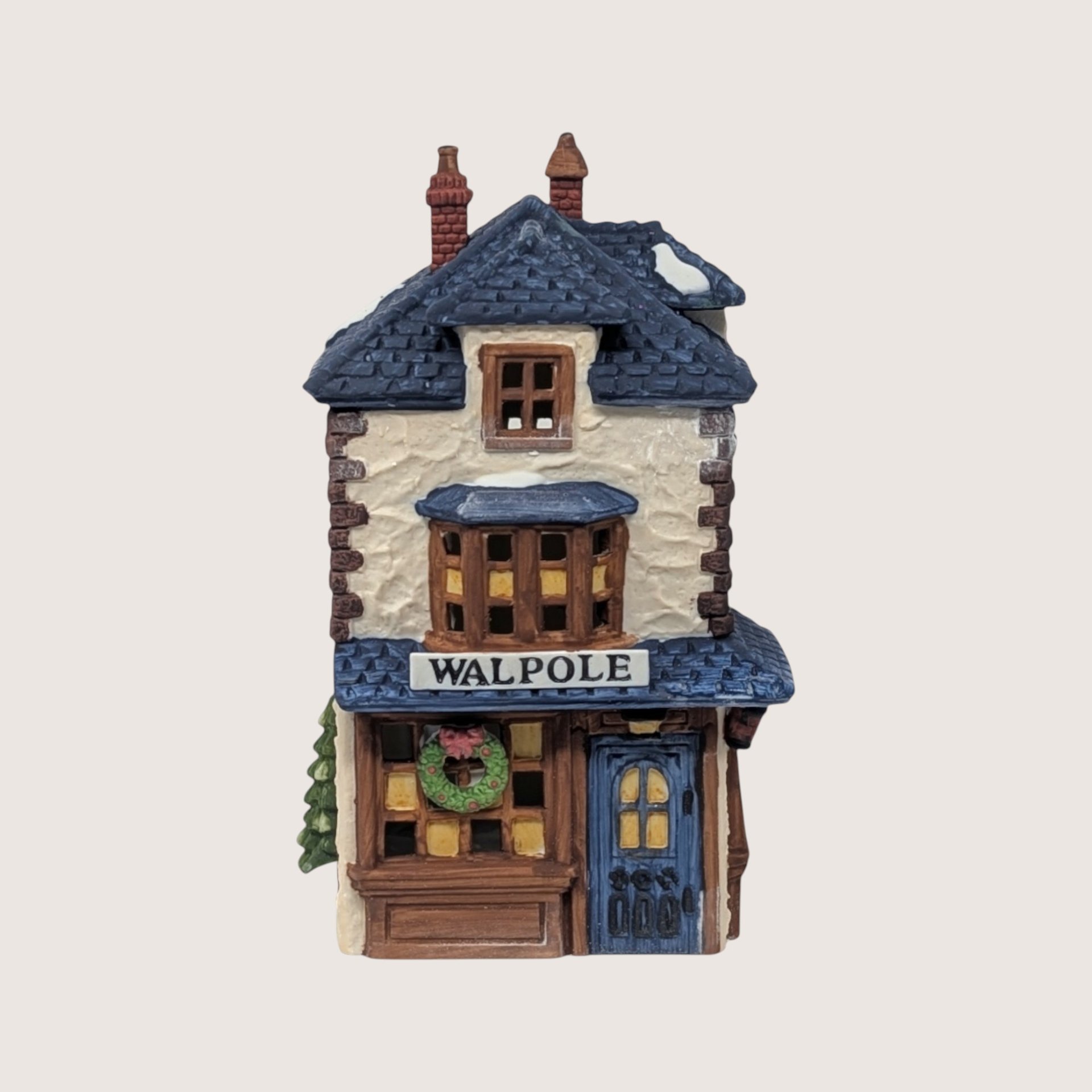 A handpainted porcelain Dept 56 Walpole Tailors shop building on a linen background