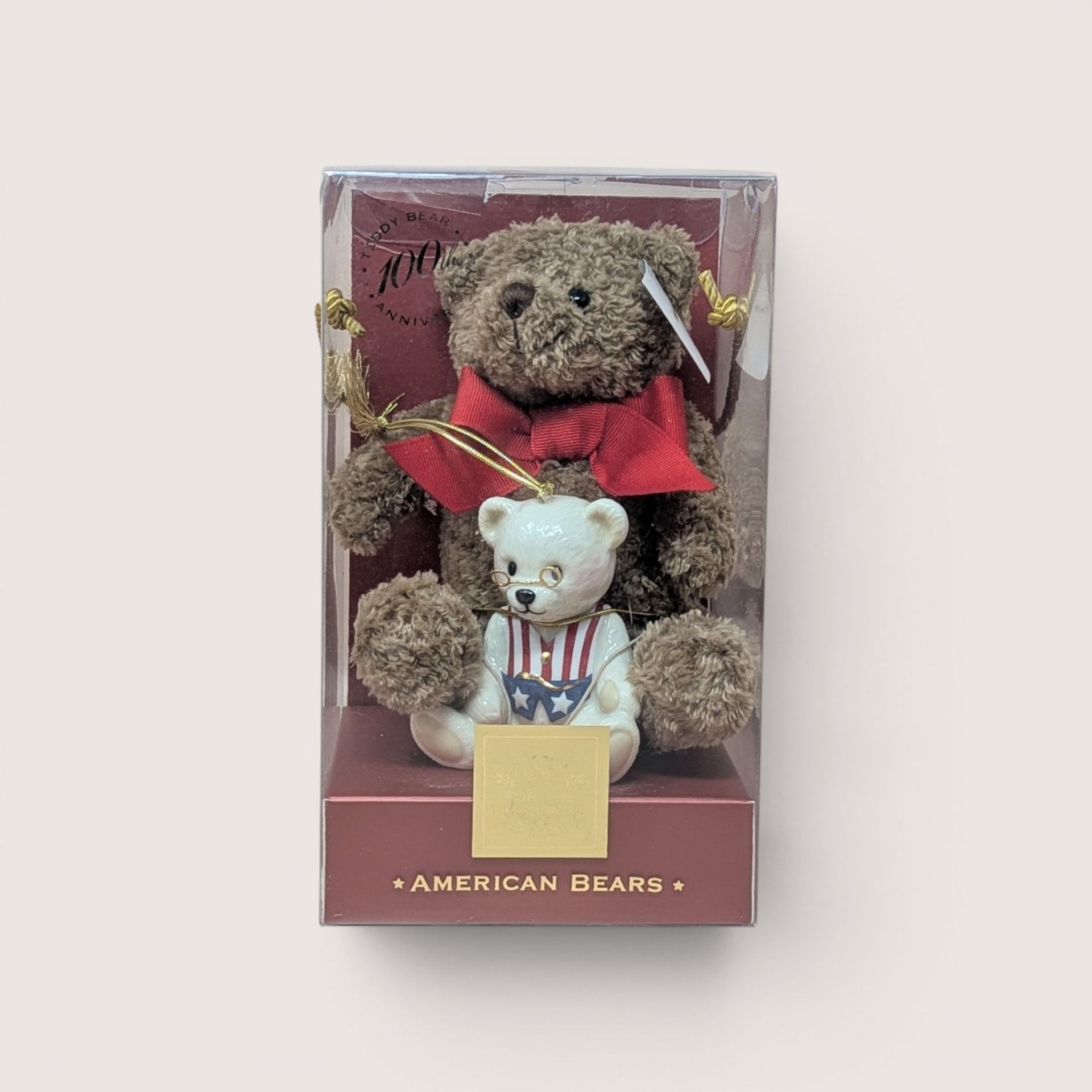 Lenox 100th Anniversary American Bears set with a brown plush teddy bear cradling a white patriotic porcelain ornament.
