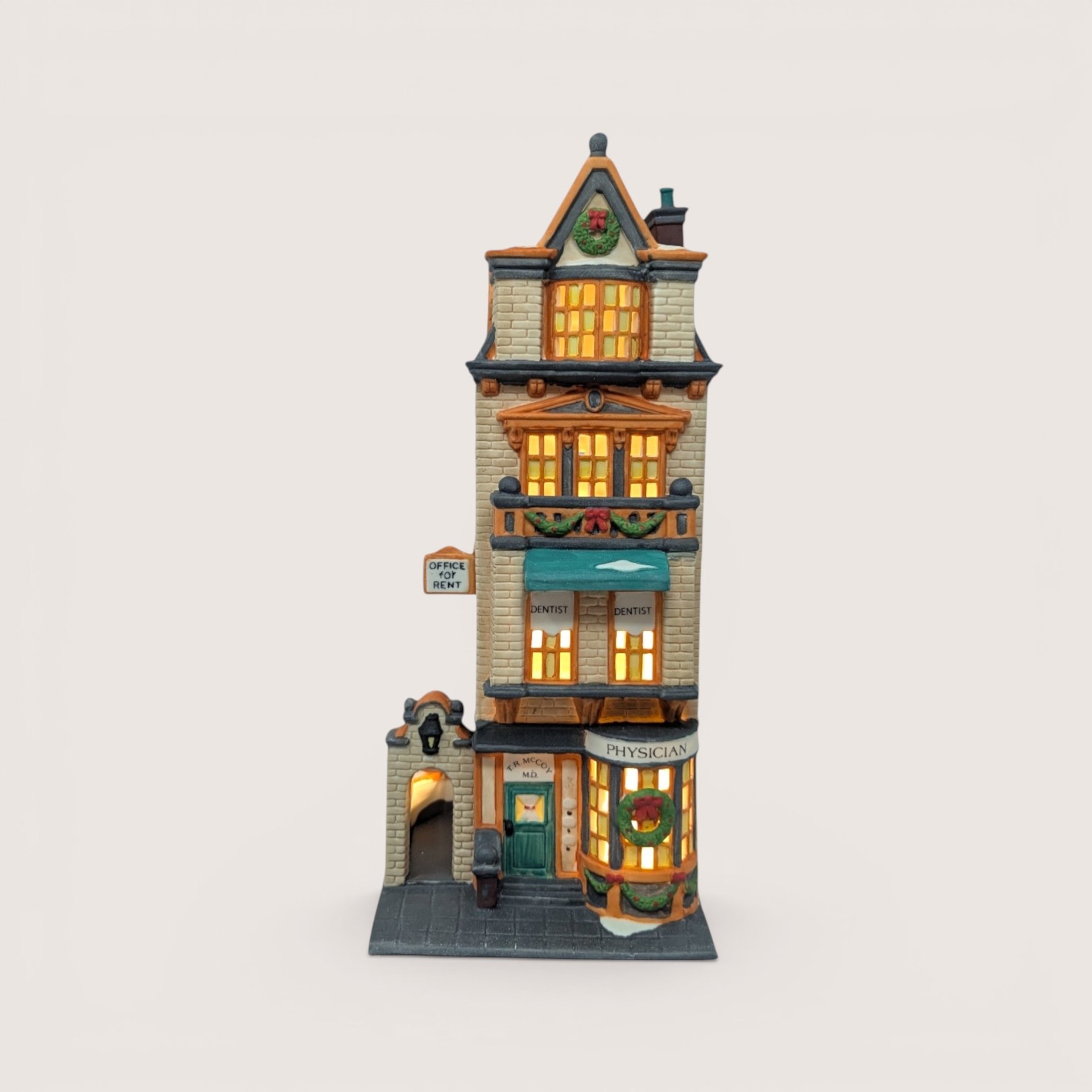 A handpainted porcelain Dept 56 The Doctors Office building on a linen background
