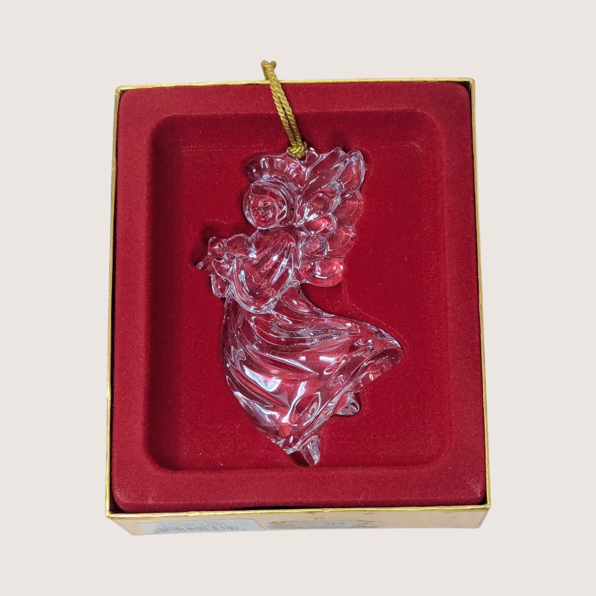 Clear crystal angel Christmas ornament holding a star inside its original gold and red velvet box.