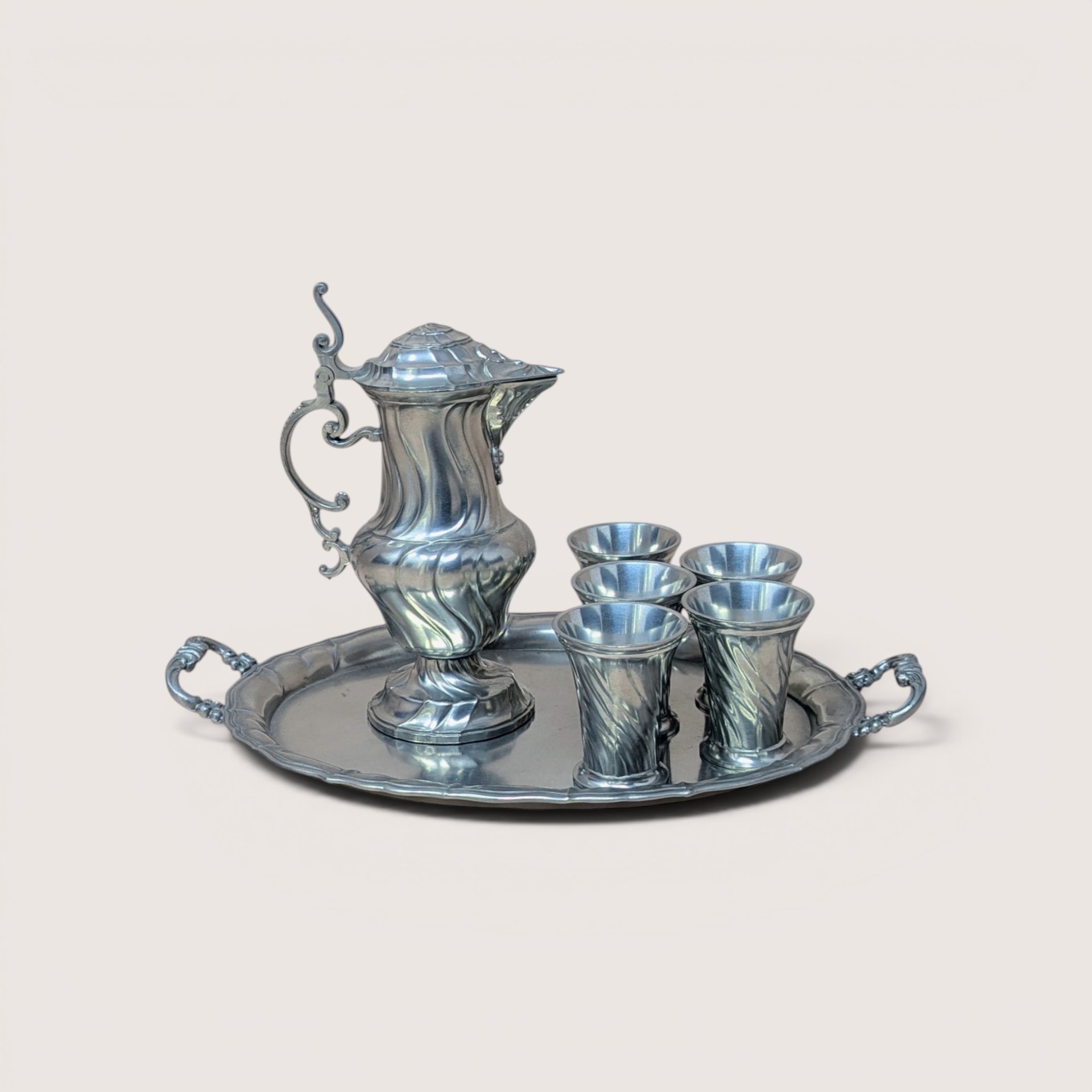 A vintage Salzburger Zinnstube Austrian pewter serving set featuring a lidded pitcher, four cups, and a handled tray.