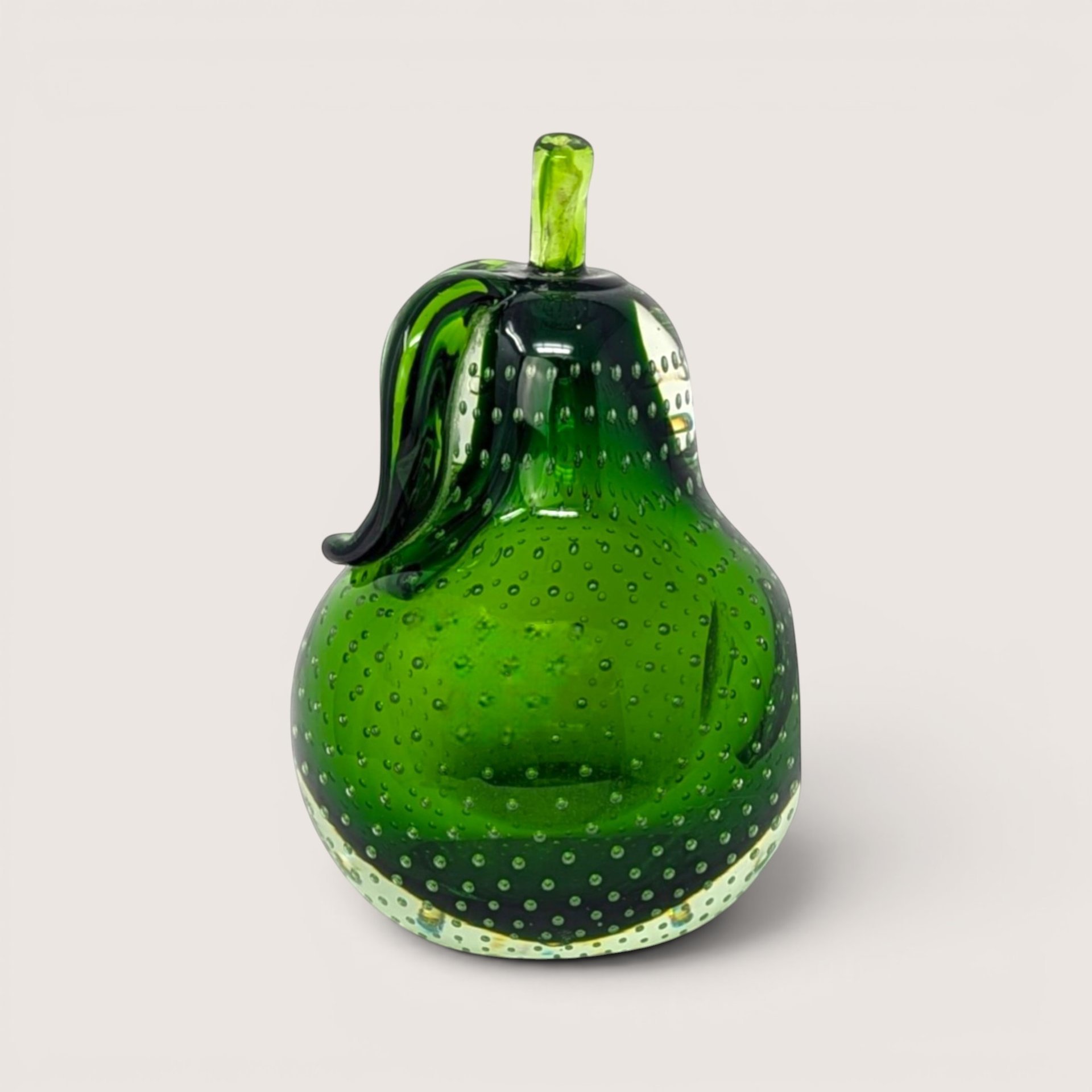 Green hand blown glass pear paperweight with a clear bullicante bubble pattern and applied stem on a solid background.