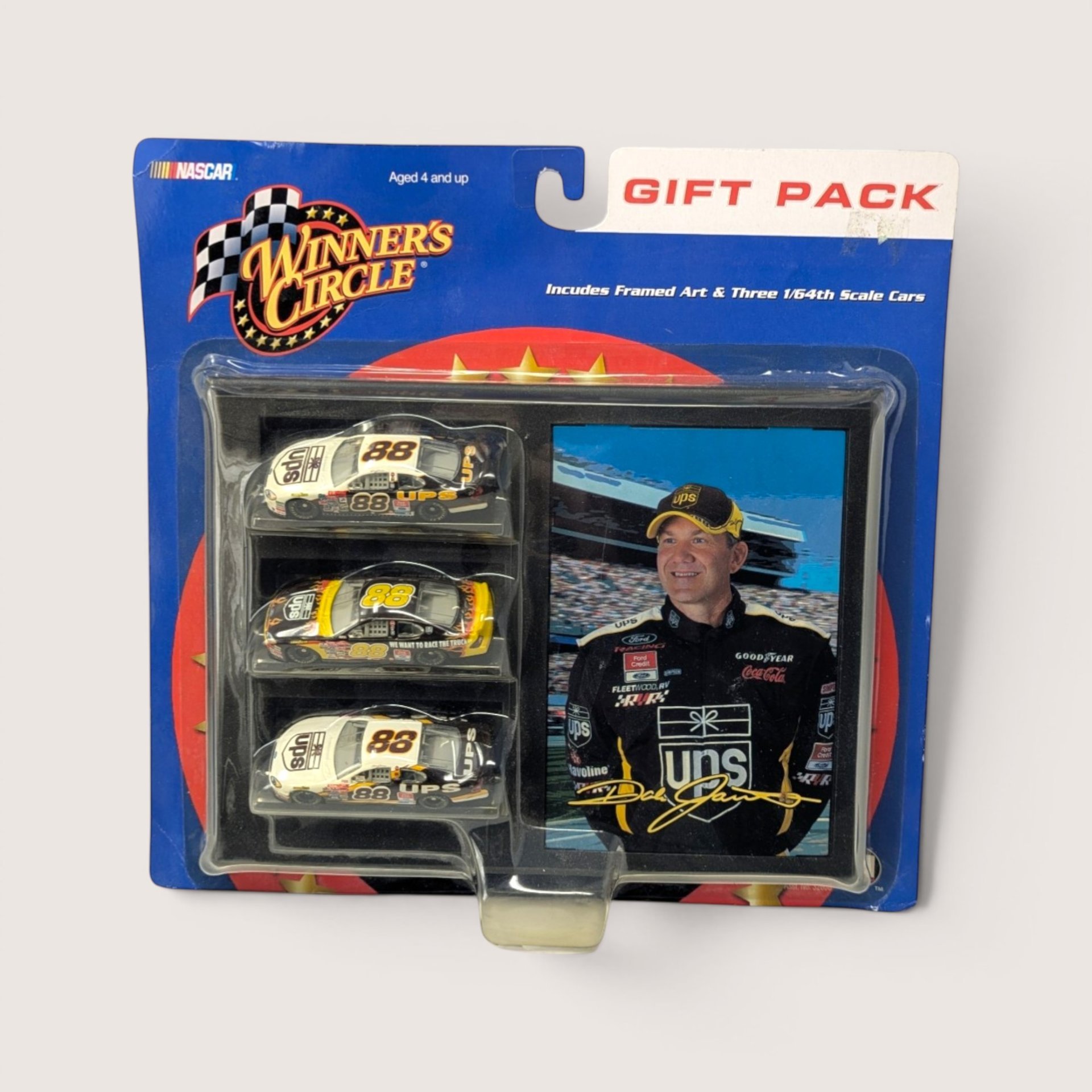 A vintage sealed NASCAR gift pack featuring a portrait of Dale Jarrett and three one sixty fourth scale UPS diecast race cars