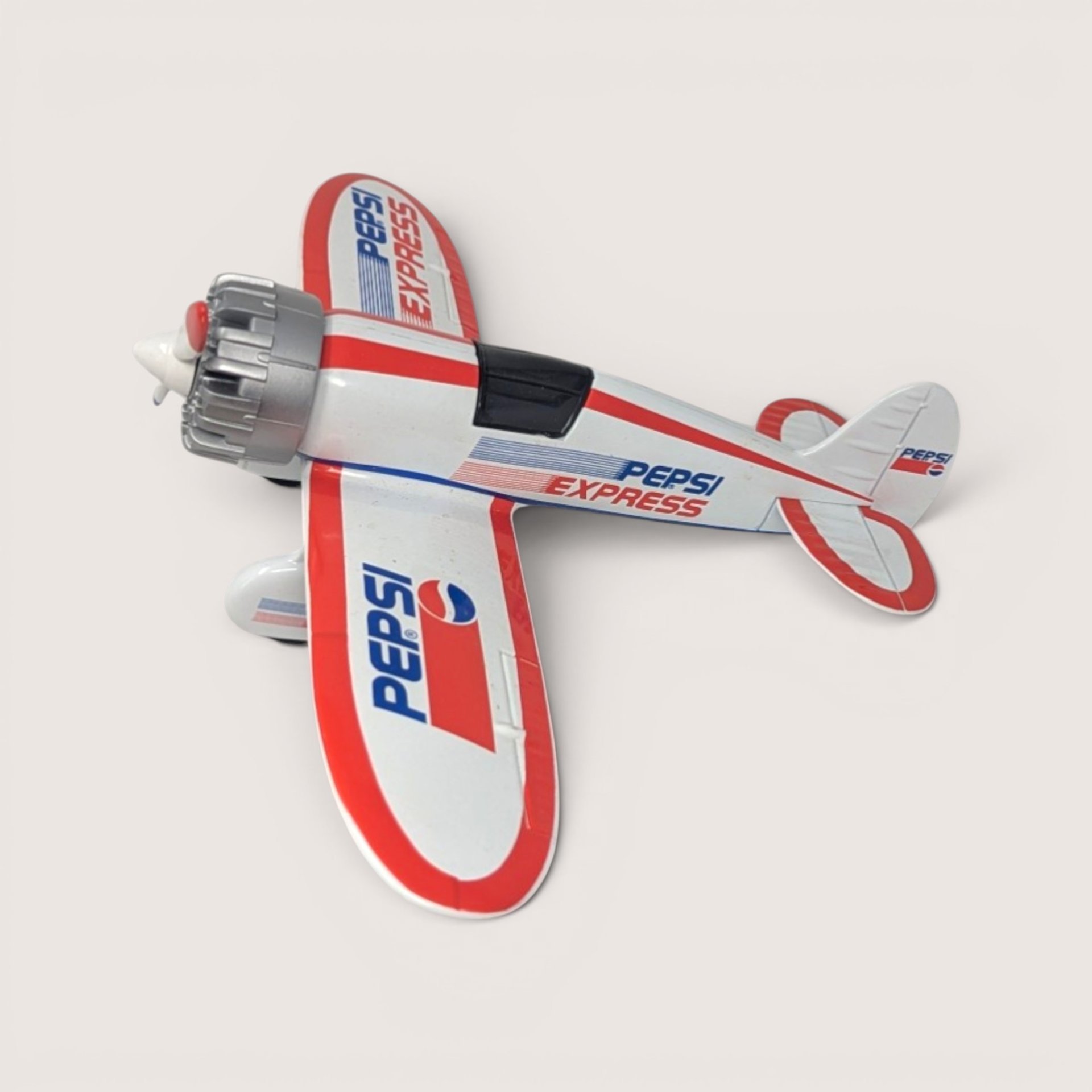 A white and red Pepsi Express 1929 Travel Air Model R die-cast airplane bank with a silver engine on a light background