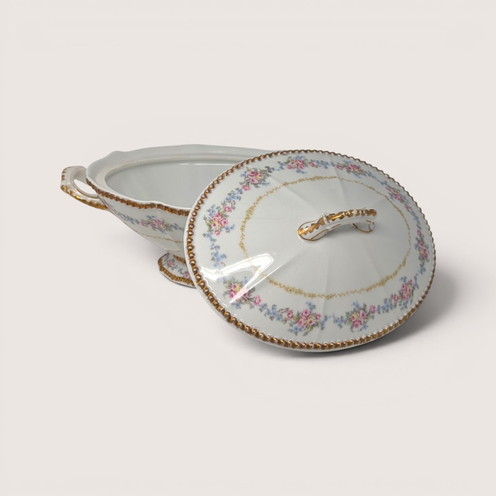 Elite Works Limoges porcelain covered bowl with pink and blue floral swags and gold trim on a white background.