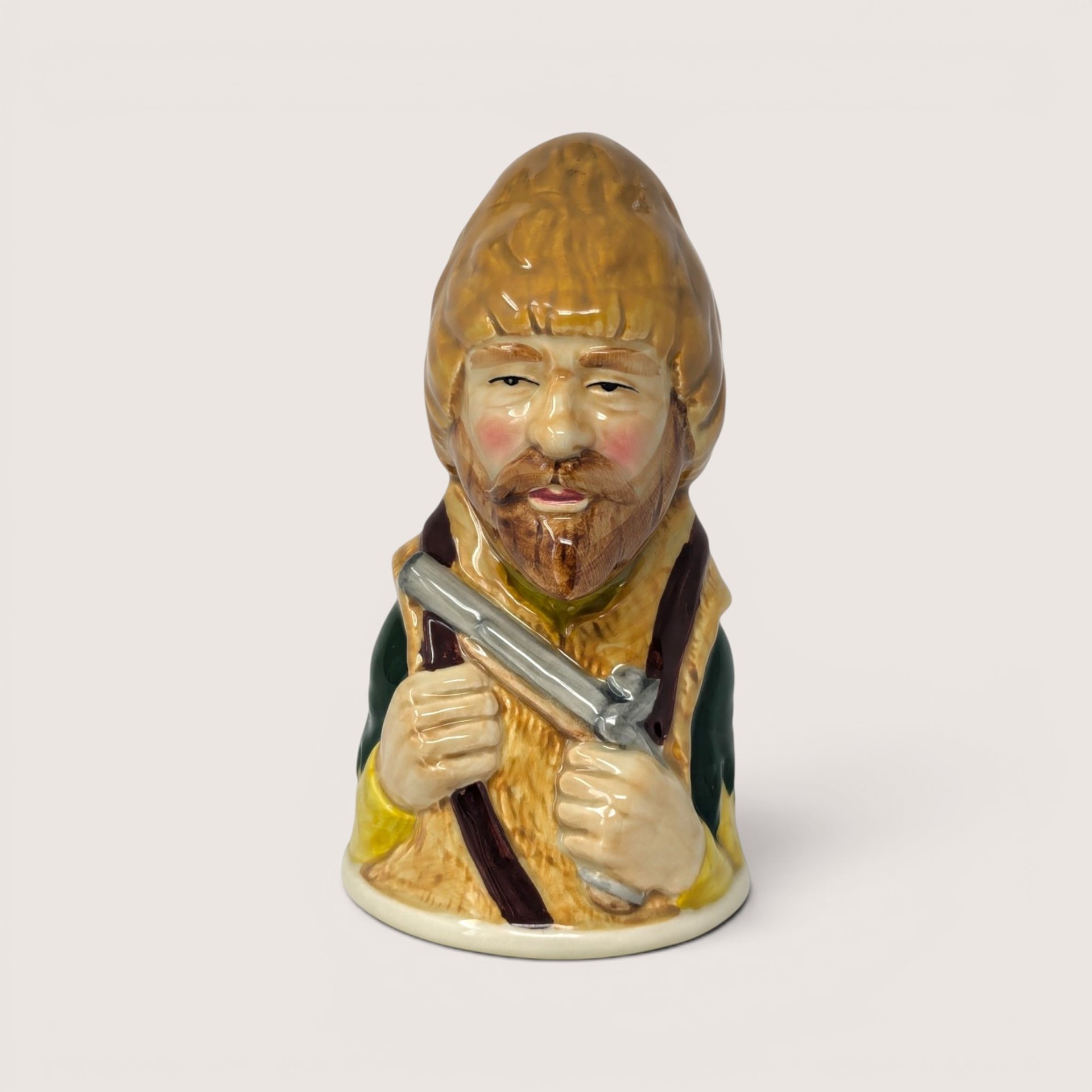 Vintage 1983 Royal Cornwall Robinson Crusoe ceramic character bell in brown and green glaze.