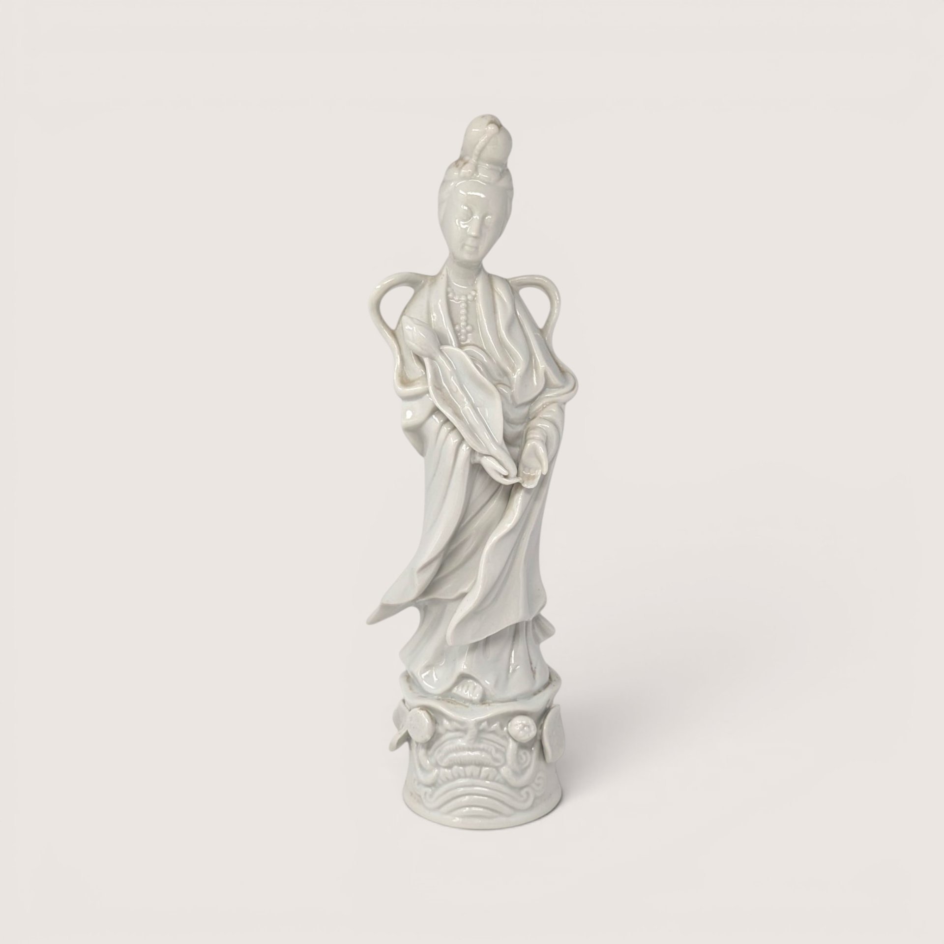 Vintage white ceramic Homco Quan Yin figurine standing on an ornate pedestal.