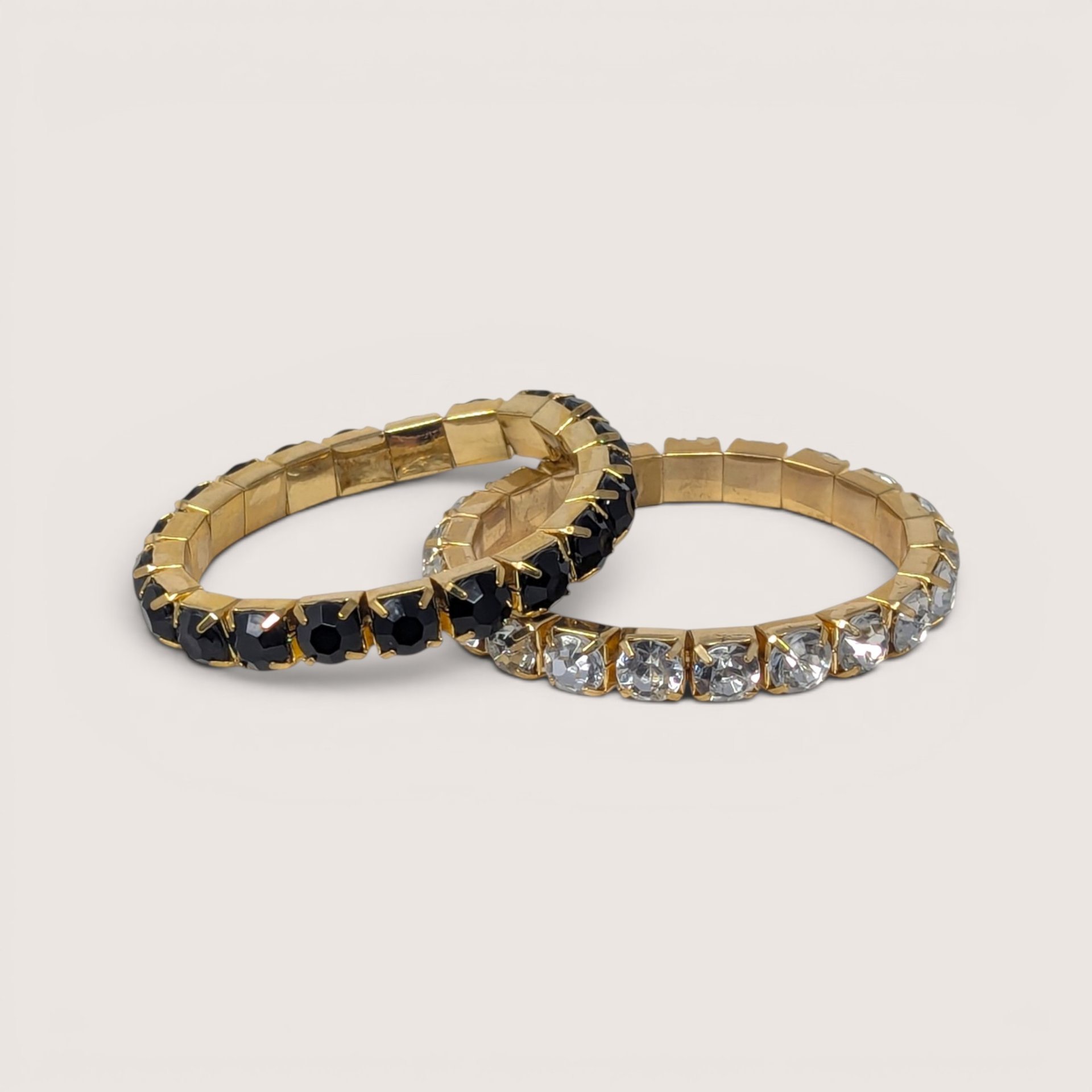 Vintage pair of gold tone stretch bracelets featuring black and clear crystal rhinestones.