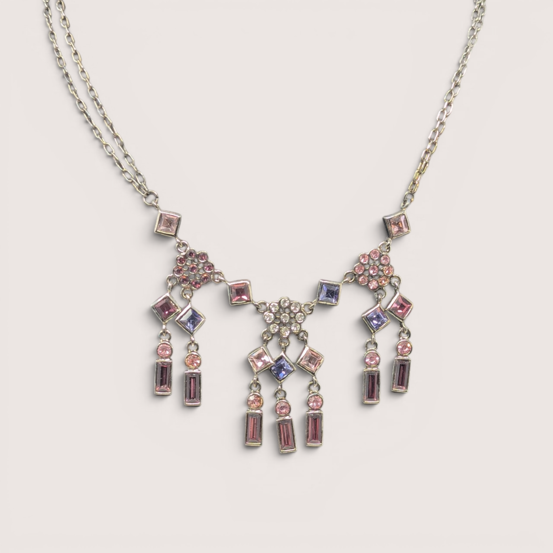 Vintage silver tone multi-color rhinestone chandelier necklace featuring pink and purple crystals.